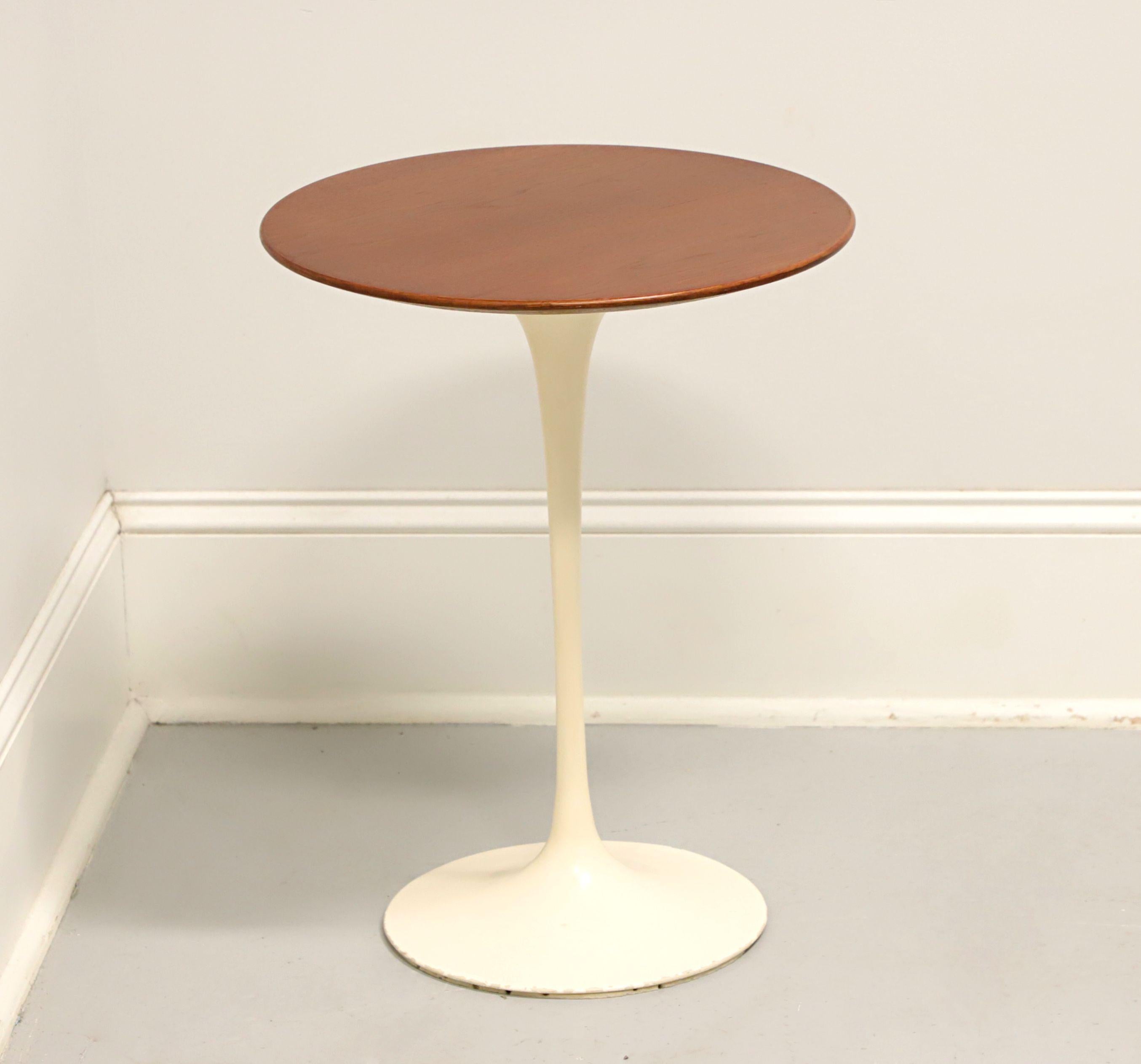 A Mid 20th Century Modern style round side table by Finnish-American designer, Eero Saarinen, for Knoll. Walnut top with a cream color painted aluminum base and having a uniquely modern tulip shape design. Made in the USA, circa 1972.

Measures: 16w