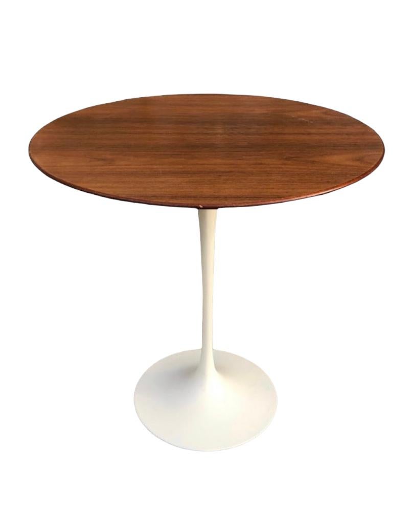 Stunning walnut side table. 20 in diameter circular wood top finished in walnut. Like new original surface. Retains original early Knoll bow tie label on underside. Cast iron base is very heavy and sturdy. Base has been recoated and has even color.