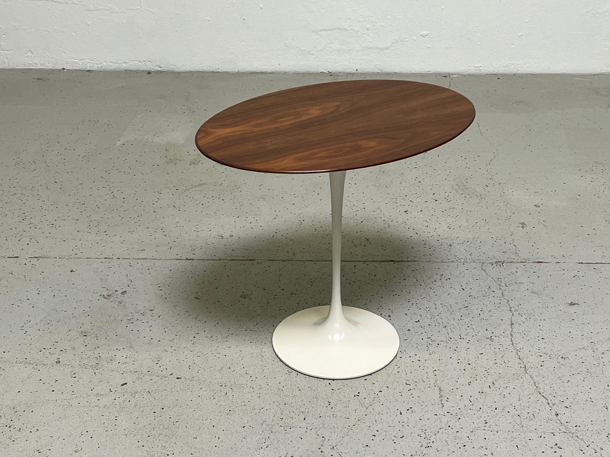 An early walnut top elliptical tulip side table designed by Eero Saarinen for Knoll.