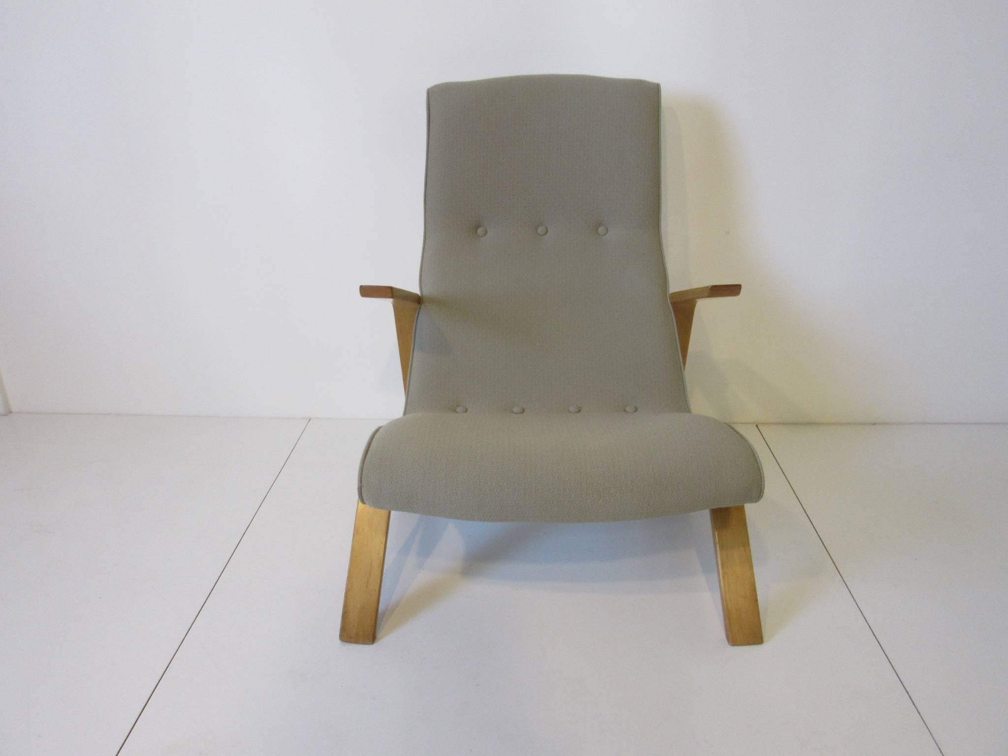 An upholstered grasshopper lounge chair in a seafoam green fabric with birch wood sculptural arms and legs, a early vintage version of this icon chair. Manufactured by Knoll.