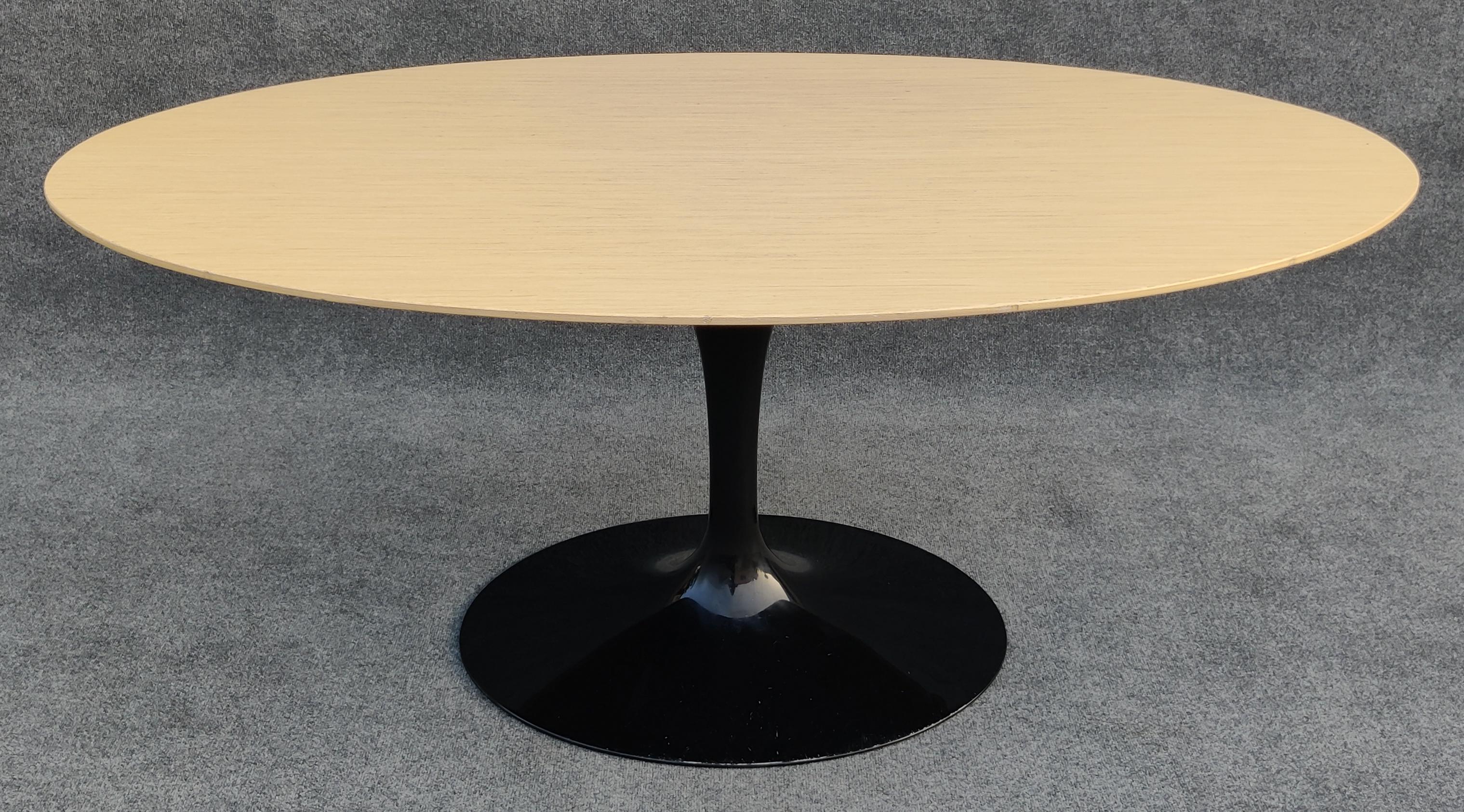 Signed and dated Eero Saarinen for Knoll oval Tulip dining table in blond wood with oval plastic-coated cast-aluminum base. This table has an unusual size that was likely a custom order. It is just the right size to be an ample 6-person table in a