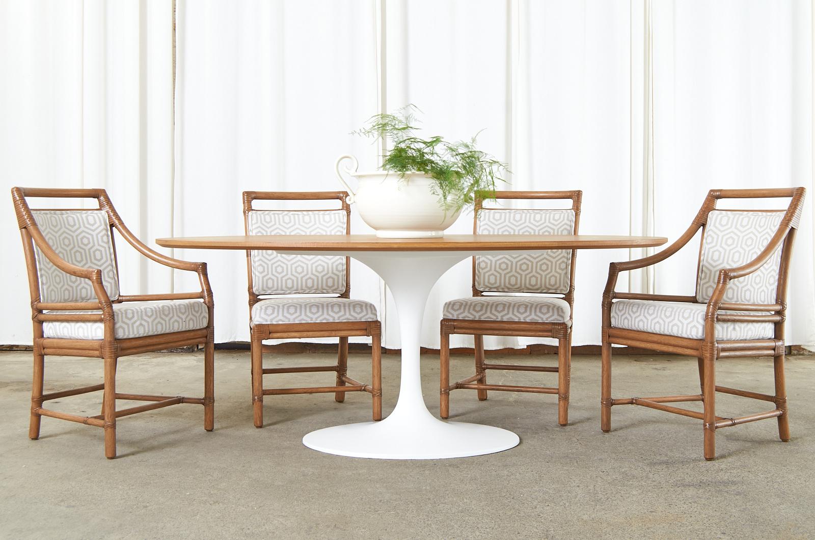 Mid-Century Modern design made in the manner and style of Eero Saarinen for Knoll. The large table features a sleek oval laminate oak top with a thick beveled edge. Supported by an iconic tulip design cast iron base with a white finish. Timeless