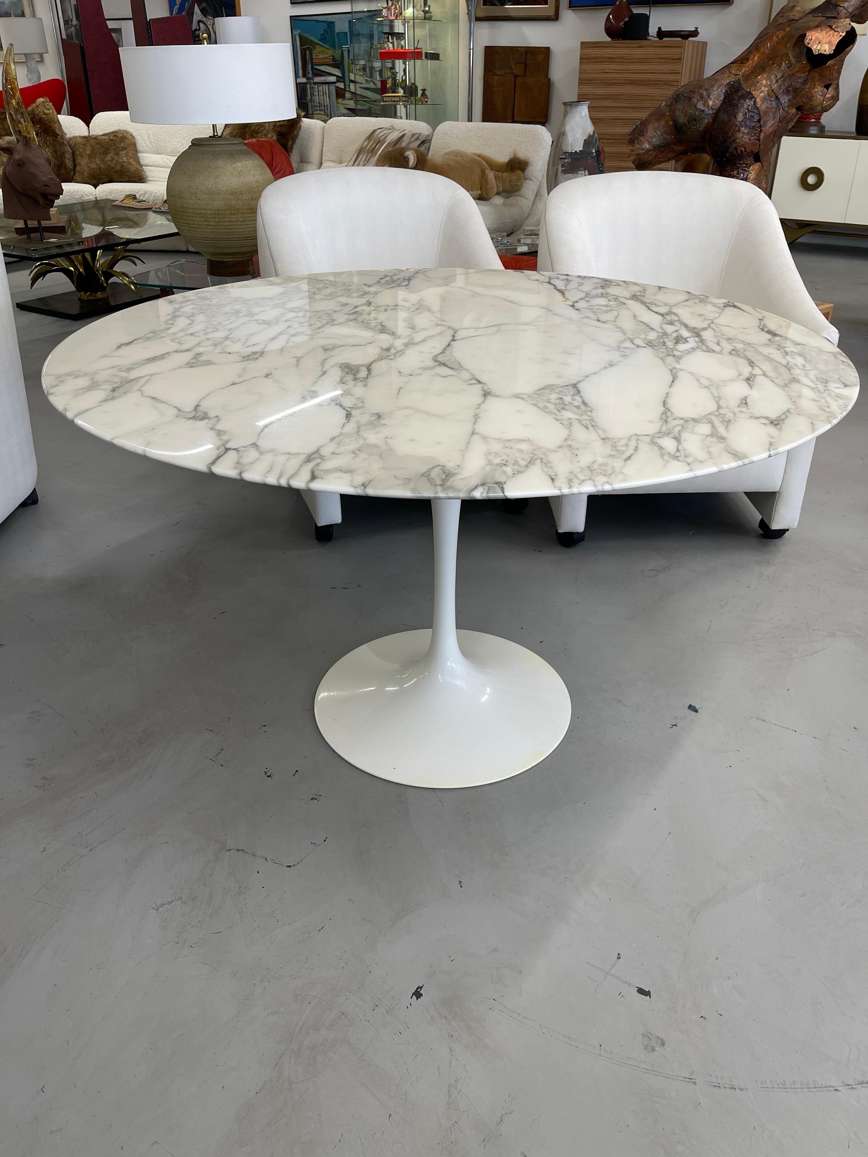 Classic Marble Eero Saarinen Tulip pedestal table. Early 2000’s vintage. Nice 47.25 inch size. Table top is in good condition with some scratches in the surface. A couple of yellow spots to the bottom, which are pictured. Scratches are hard to