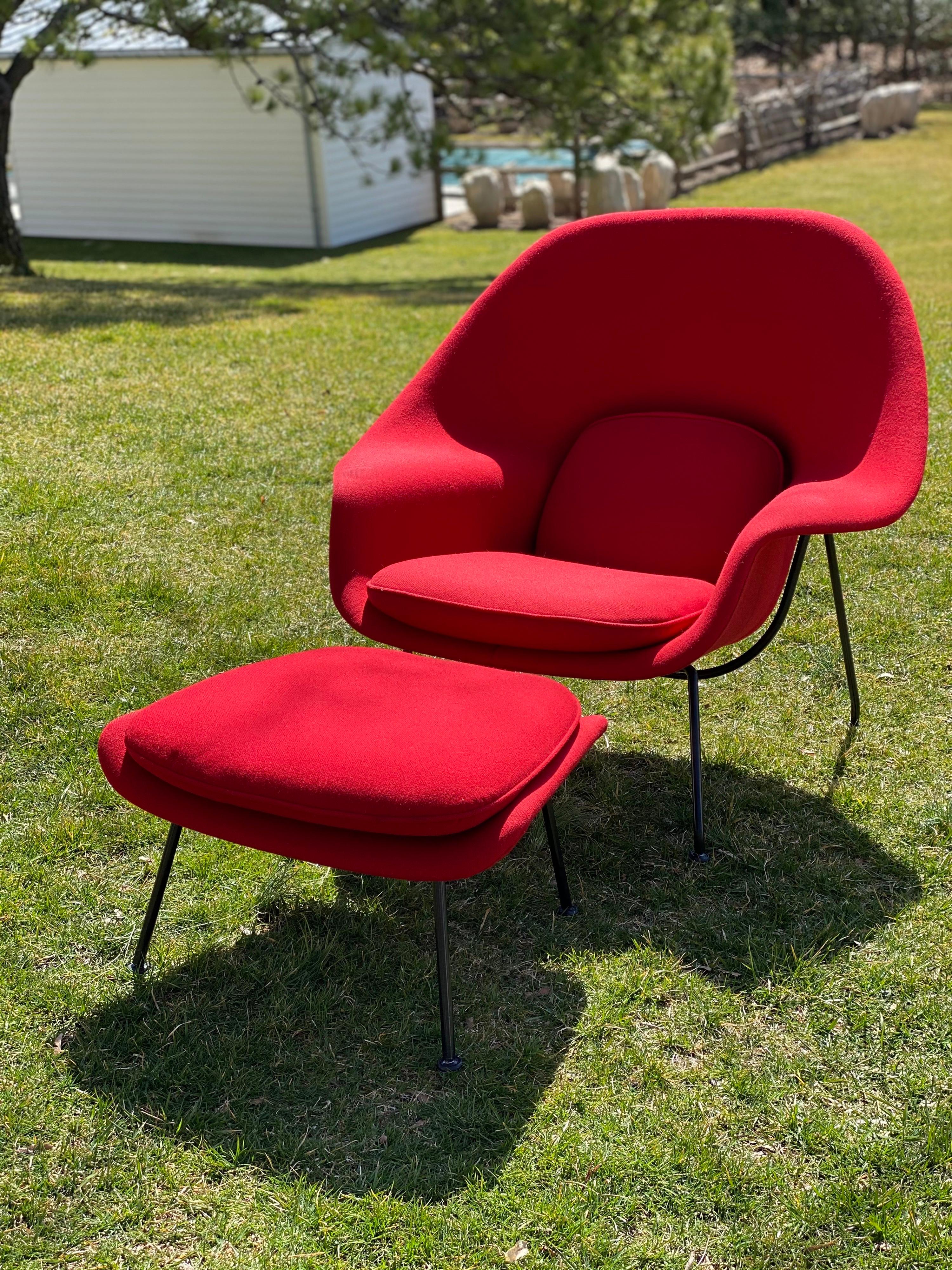 Cette chaise Womb originale et iconique, accompagnée d'un ottoman, est l'œuvre du célèbre designer finlandais/américain Eero Saarinen et a été produite par Knoll. Le fauteuil et l'ottoman ont été recouverts, il y a plus de 25 ans, d'un tissu rouge