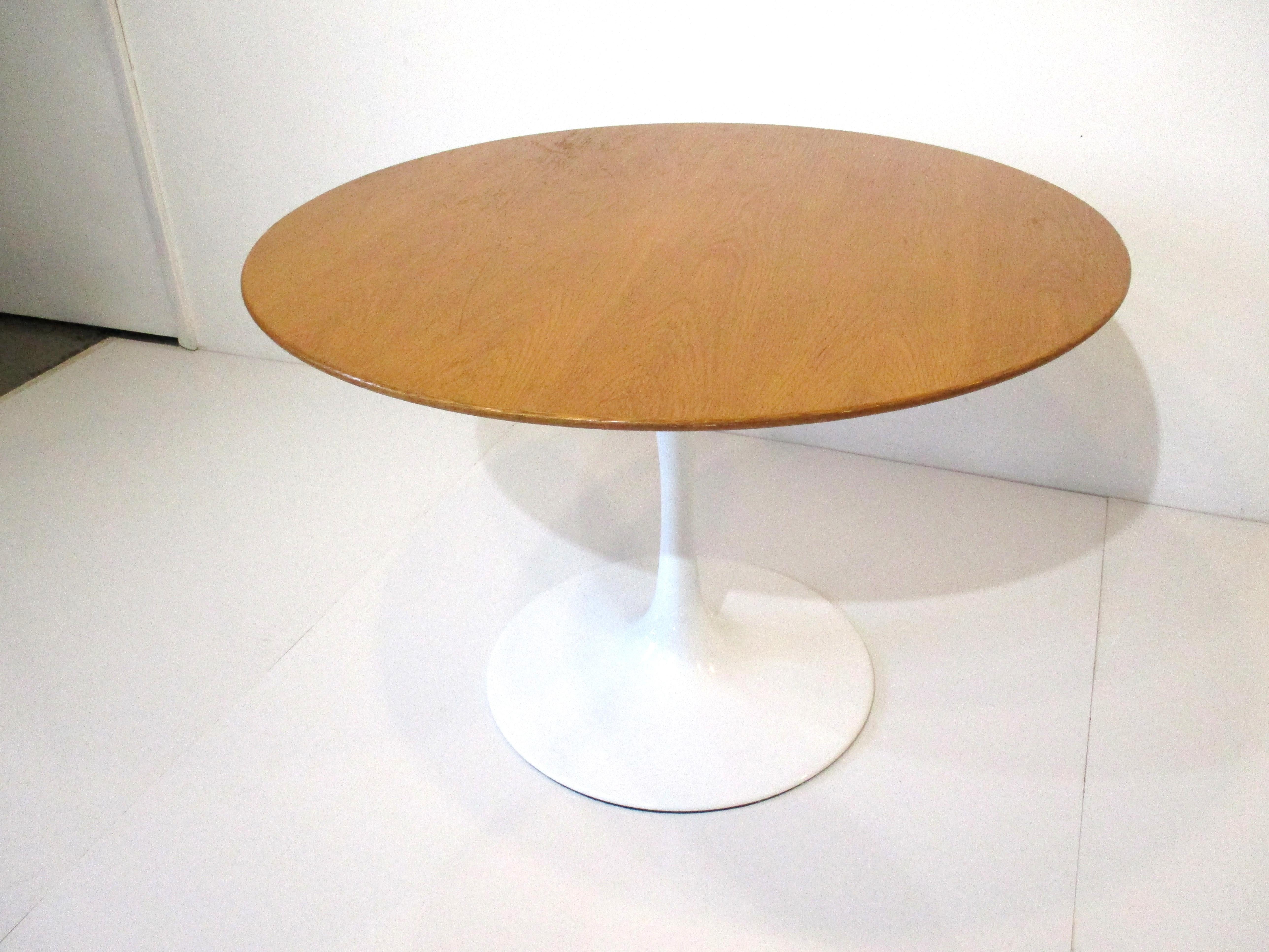 A nice sized Tulip dining or game table with American oak top on a glossy white steel tulip base . Retains the manufactures tag from Knoll International special ordered for the Weyerhaeuser Wood Company offices Tacoma, WA.