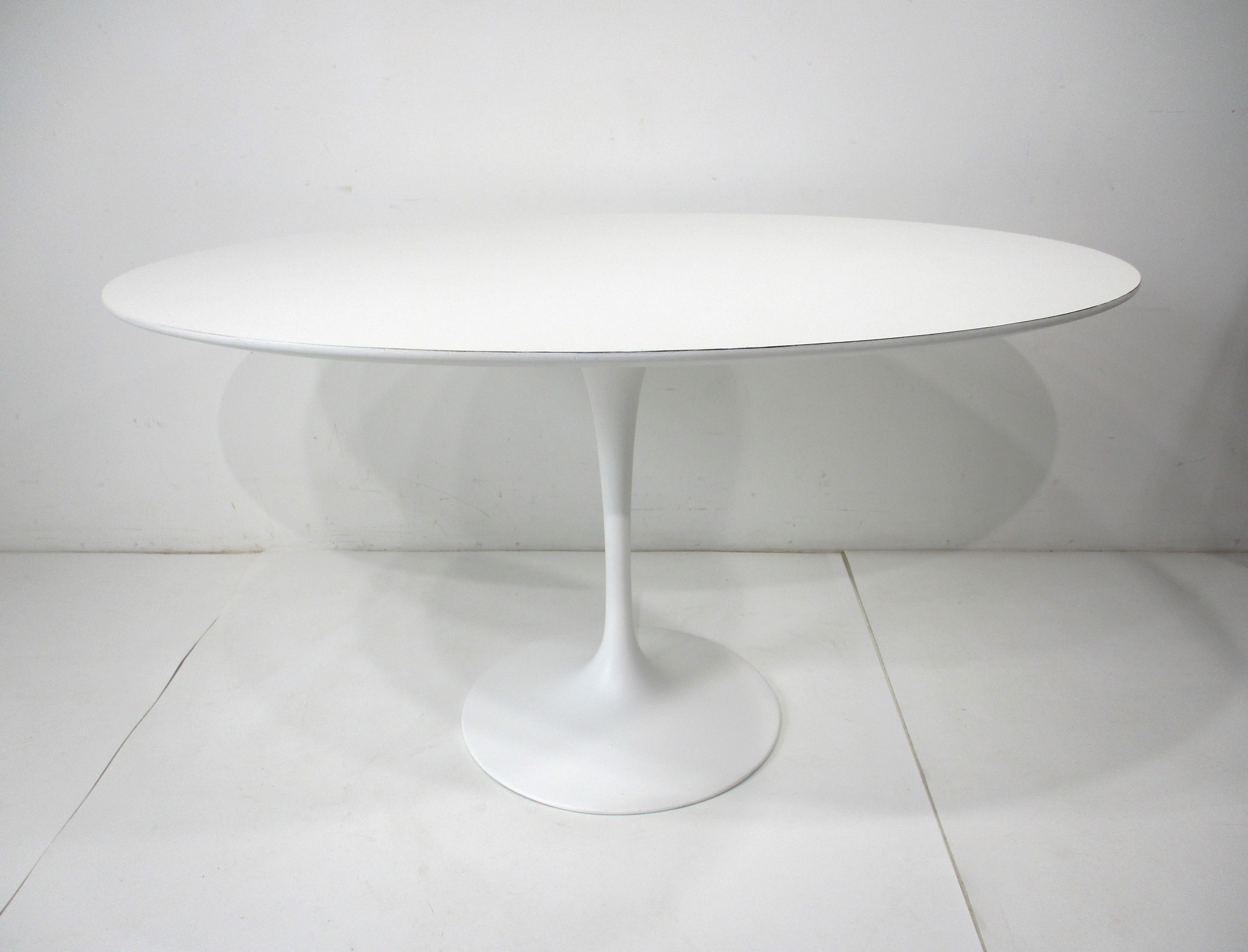 A early and rare form in a tulip table , it's a smaller oval which can be used as a desk or for a eat in kitchen . This piece was special ordered for a kitchen area having a white Laminate top and matching base . After down sizing the former owners