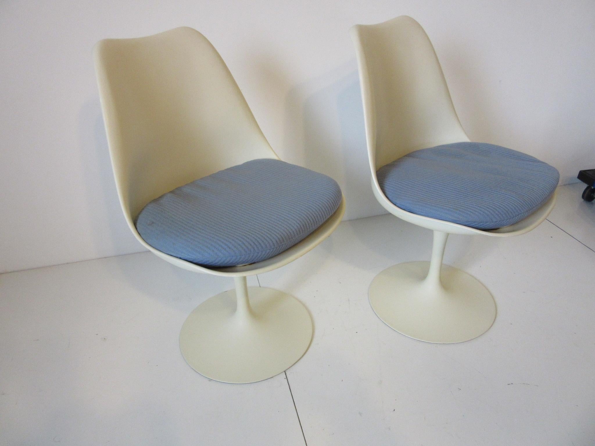 A pair of swiveling tulip chairs with sky blue fabric seat pads, perfect for that small eat in kitchen or cafe table manufactured by Knoll International.
