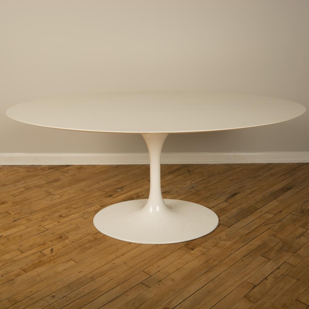 Oval dining / conference table with white laminate top and white lacquered aluminum tulip base designed by Eero Saarinen for Knoll. Circa 1963.