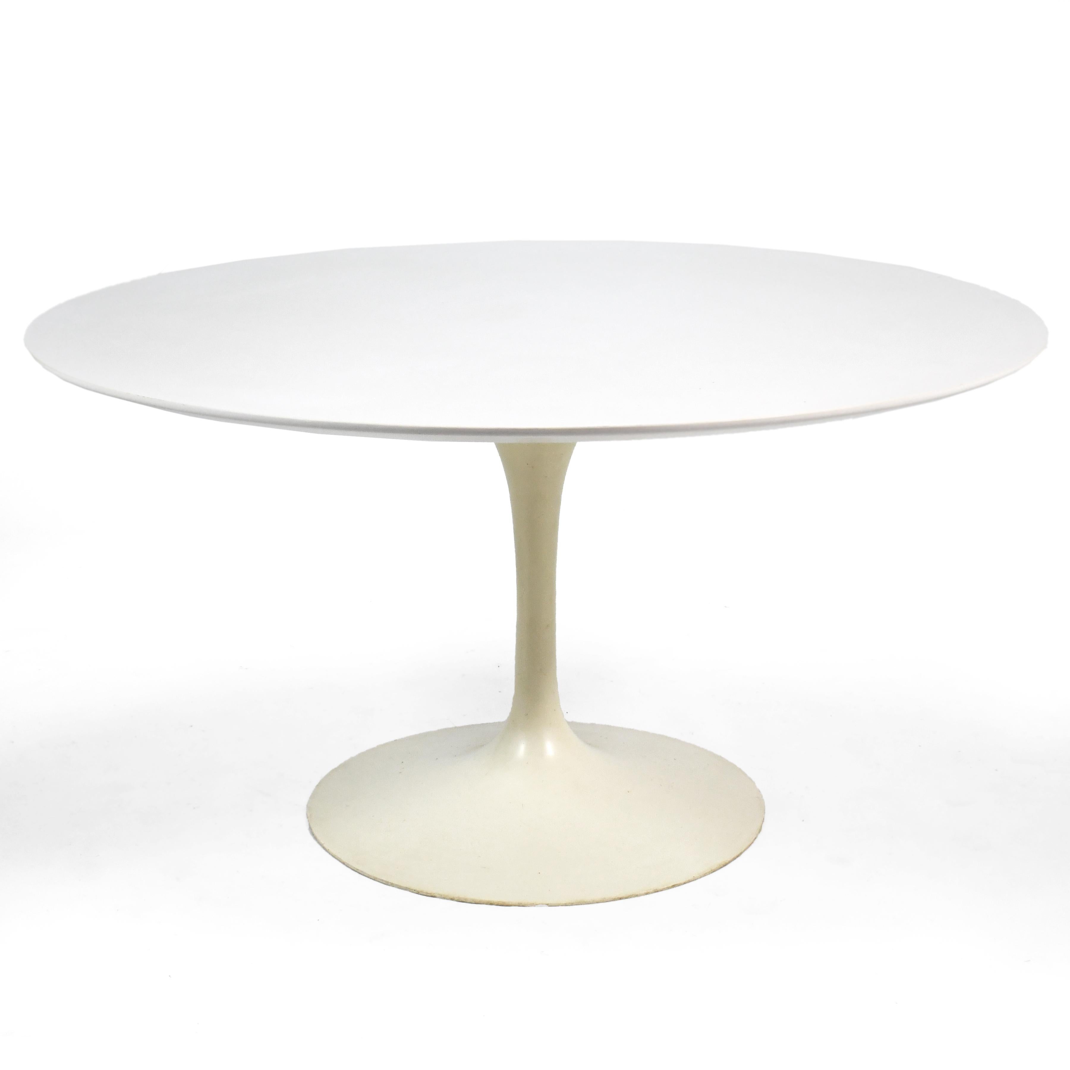 Saarinen's iconic design never goes out of style and works beautifully with almost any dining chairs. This wonderful vintage example from 1967 features a heavy base of cast iron supporting a white mica top. The finish on the base has patinated and