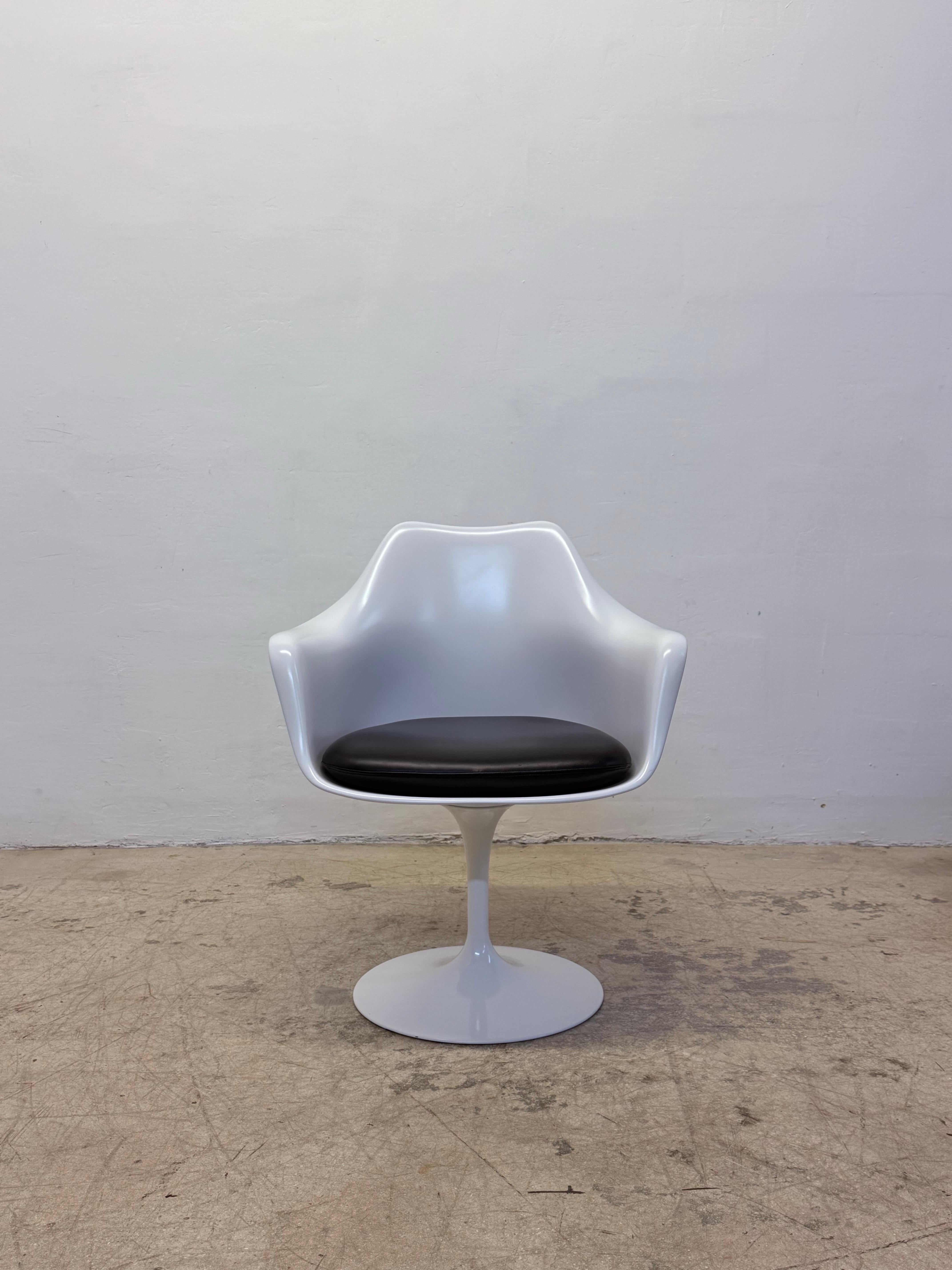 Pareja de sillones giratorios de la colección Tulip Pedestal con cojines de vinilo negro Prairie sin ftalatos y bases de aluminio fundido lacado en blanco, diseñados originalmente por Eero Saarinen en los años 50 para Knoll.  Estas sillas se