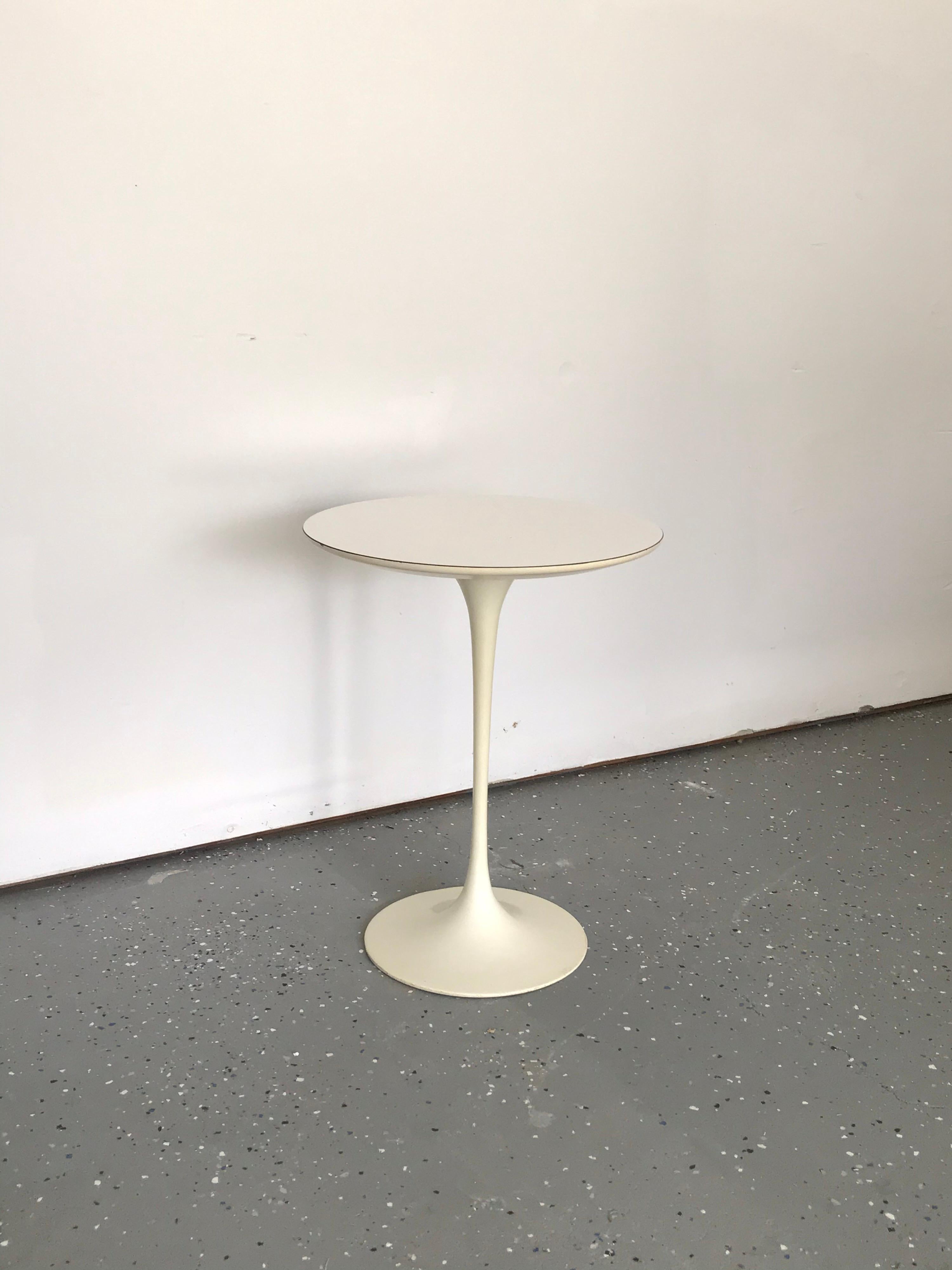Fantastic and early example of an Eero Saarinen side table. Heavy iron base supports a white laminate top. Very very good vintage condition including an exceptionally clean tag.