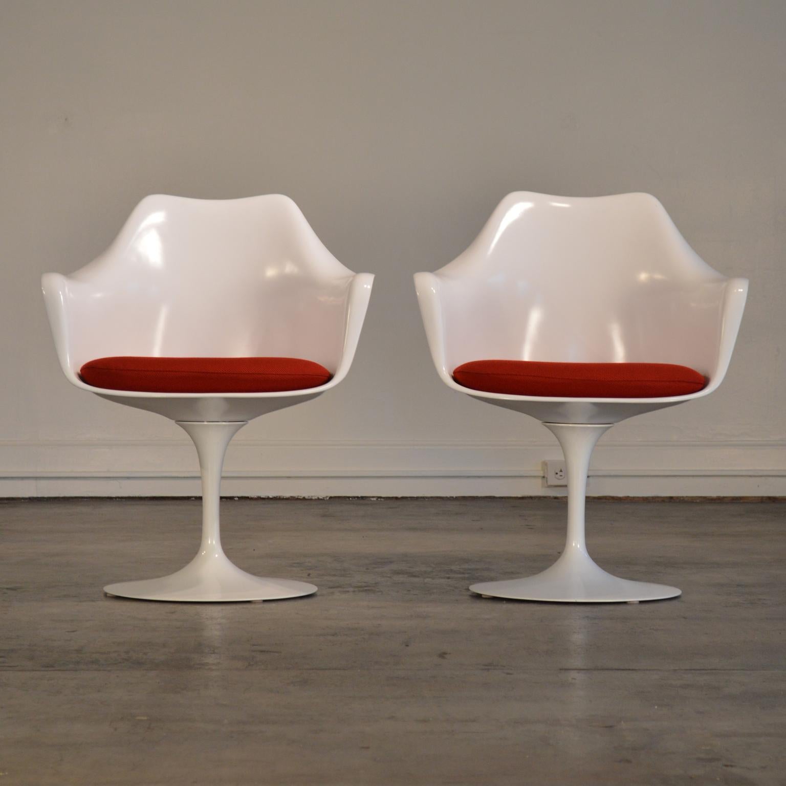 Produced by Knoll in the 21st century, this pair of tulip armchairs are a modern classic in excellent condition, showing very few signs of wear. 

Standard red cushions sit atop fully-functional swivel bases. No chips to edges, very little wear to
