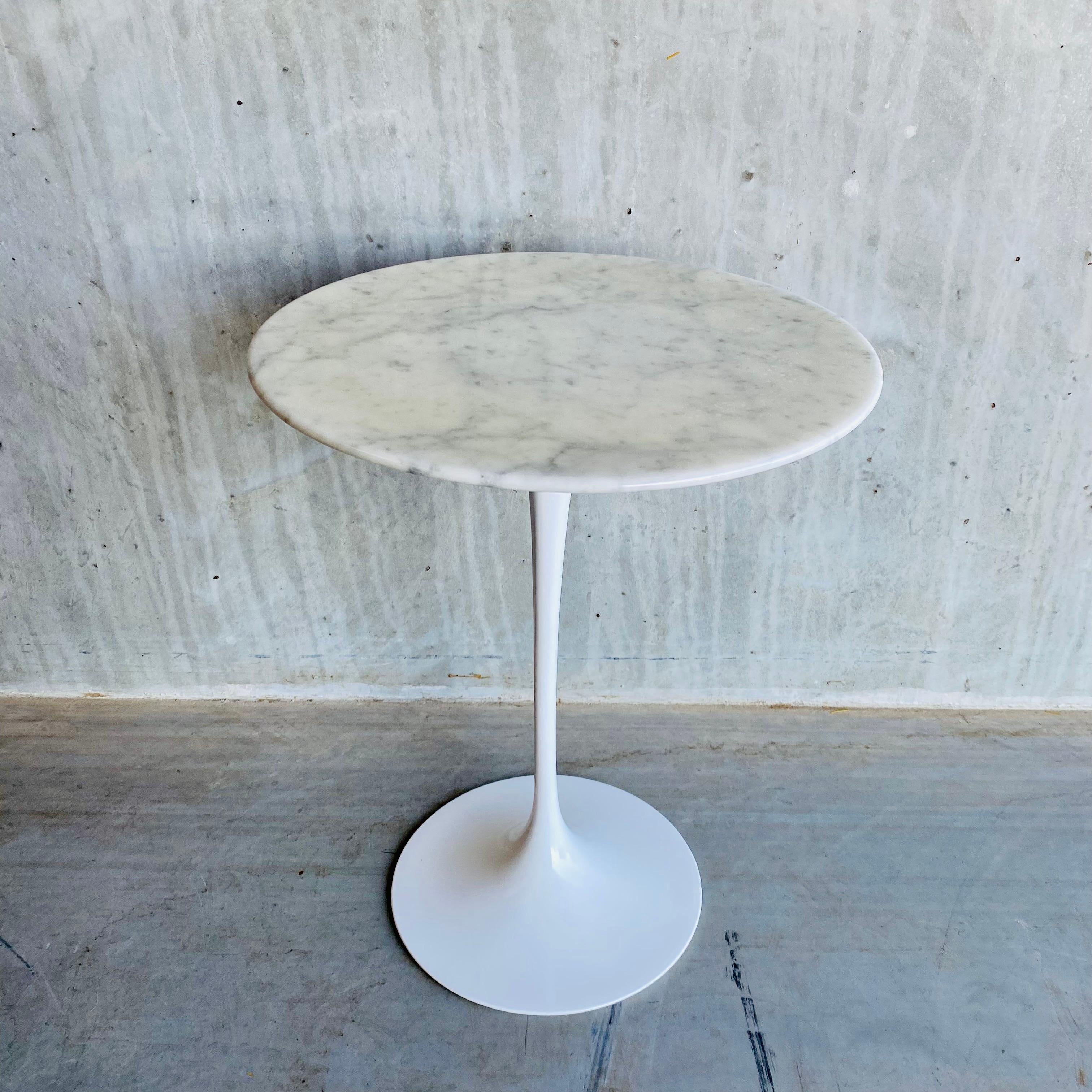 Introducing the Knoll side table by Eero Saarinen, a timeless masterpiece of midcentury design. Crafted in 1960, this side table boasts a sleek and elegant design, with a beautiful Carrara rond top and a sturdy cast iron tulip base. Measuring 41 cm