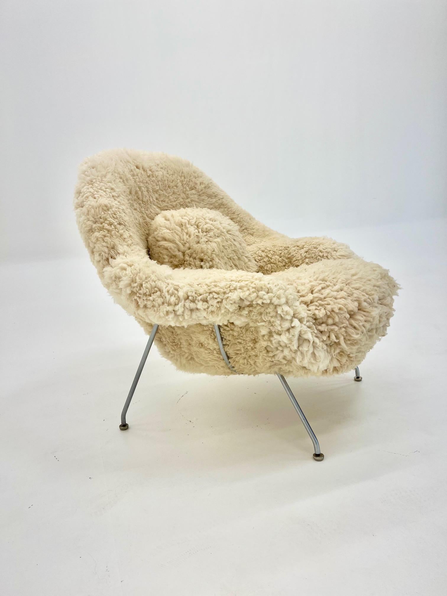 Relax and unwind in this beautifully comfortable original Eero Saarinen Womb Chair and ottoman set. The chair is accompanied by an ottoman of which both are fully reupholstered in high grade New Zealand sheepskin. Fully reupholstered with a new