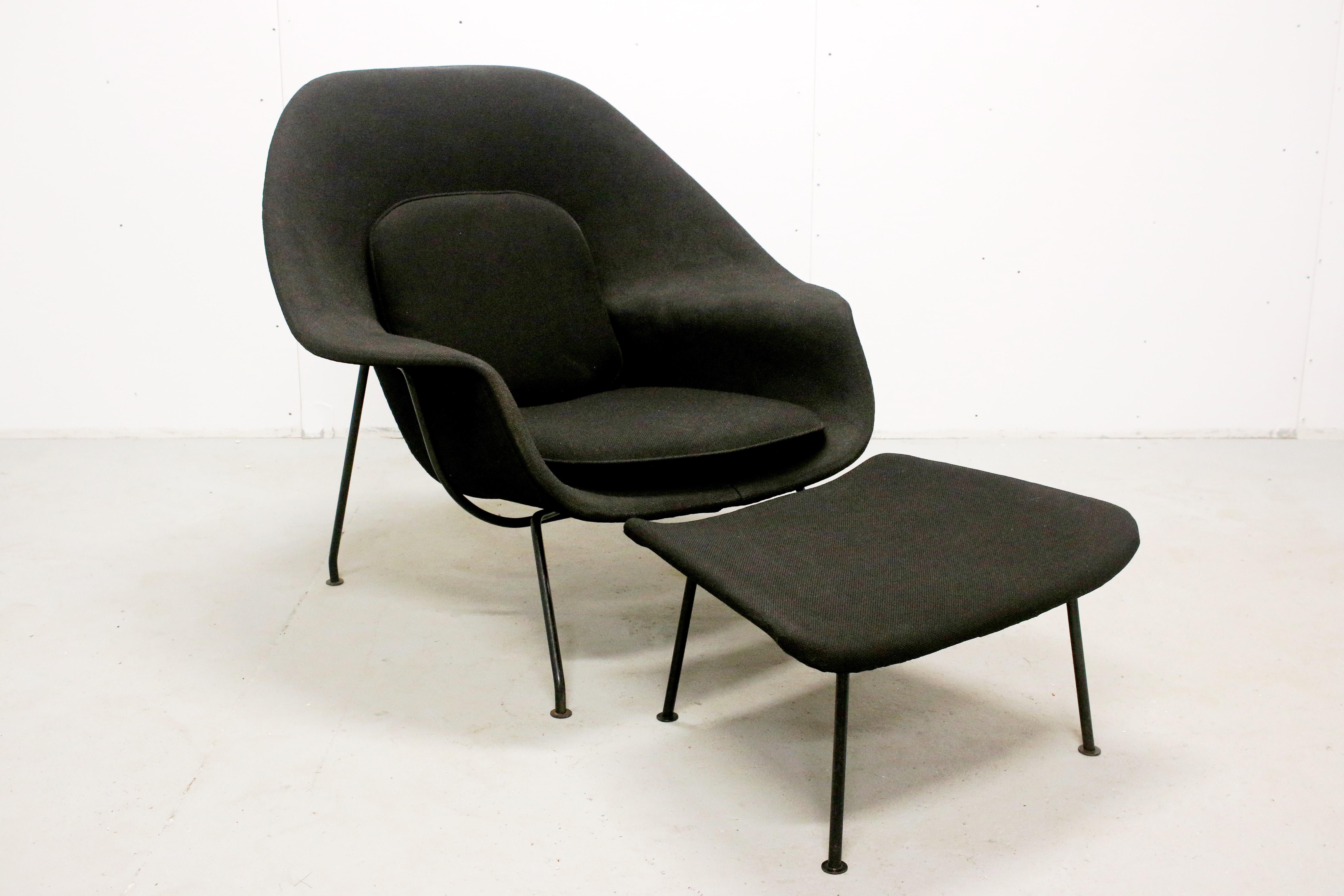 Eero Saarinen Womb Chair and Ottoman, made by Knoll, USA, 1950s-1960s. Early production with black enameled steel frame. Some age appropriate signs of use and wear to black fabric, no rips or tears. Could be reupholstered in new fabric if desired.