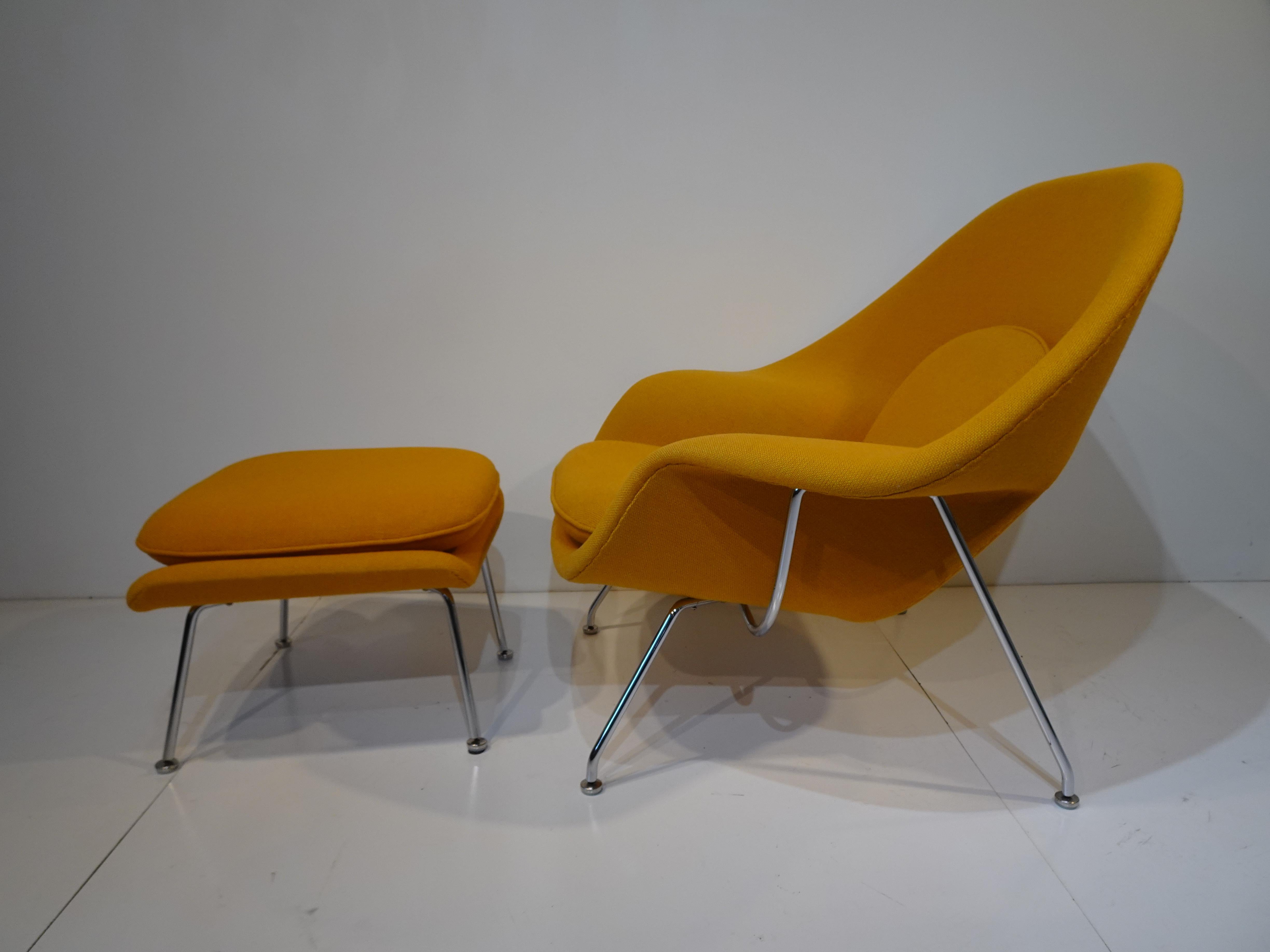 A womb chair with matching ottoman in a orange / yellow woven wool blend fabric sitting on chromed steel legs with nylon foot pads to protect your floors . This is the iconic lounge chair next to the Eames 670 from the 1960's - 70's that just sets