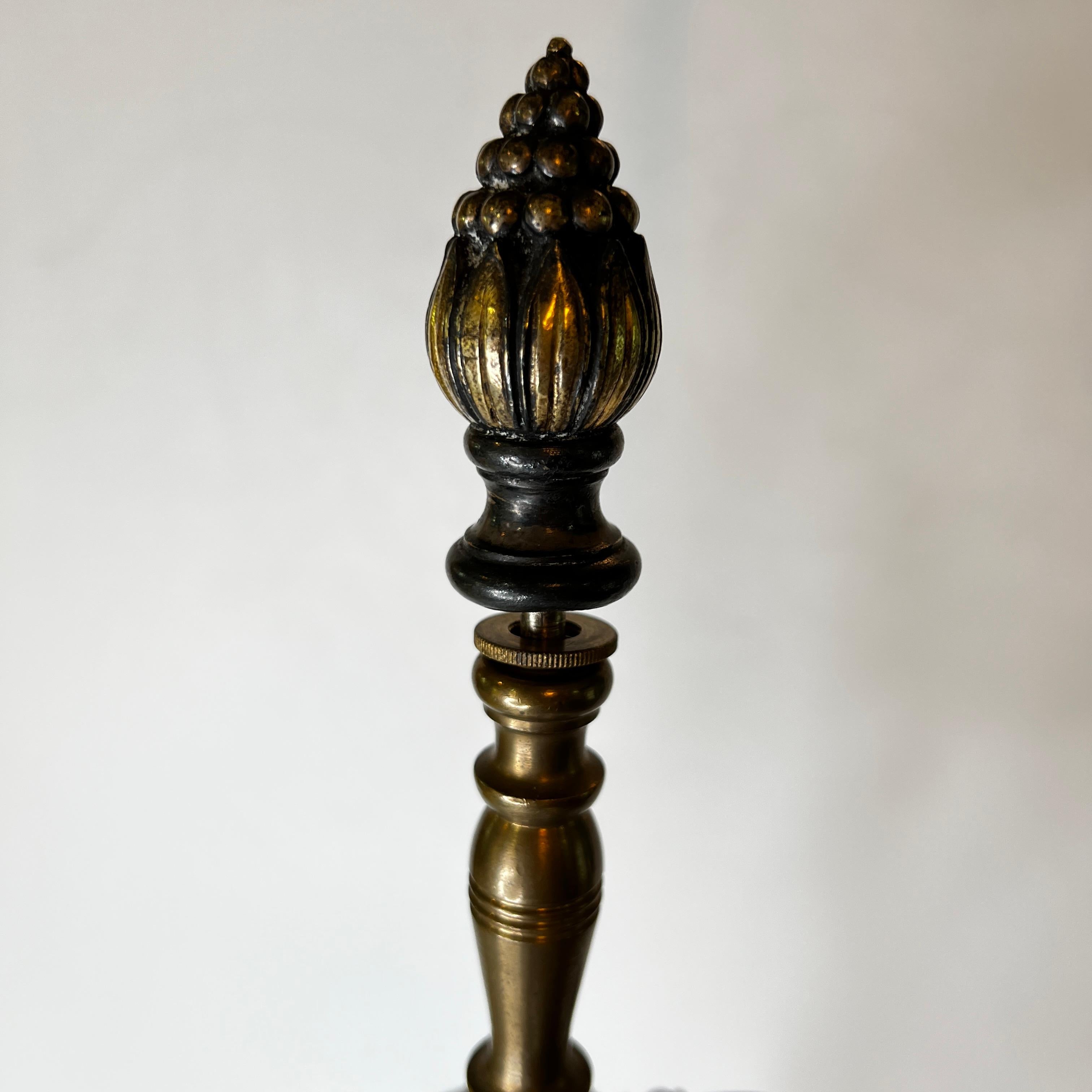 Notre lampe de table en métal argenté avec des motifs dorés de style renaissance provient d'Edward F. Caldwell, vers 1910. 

Elle possède son épi de faîtage d'origine et présente des motifs néoclassiques en relief, notamment des rinceaux, des