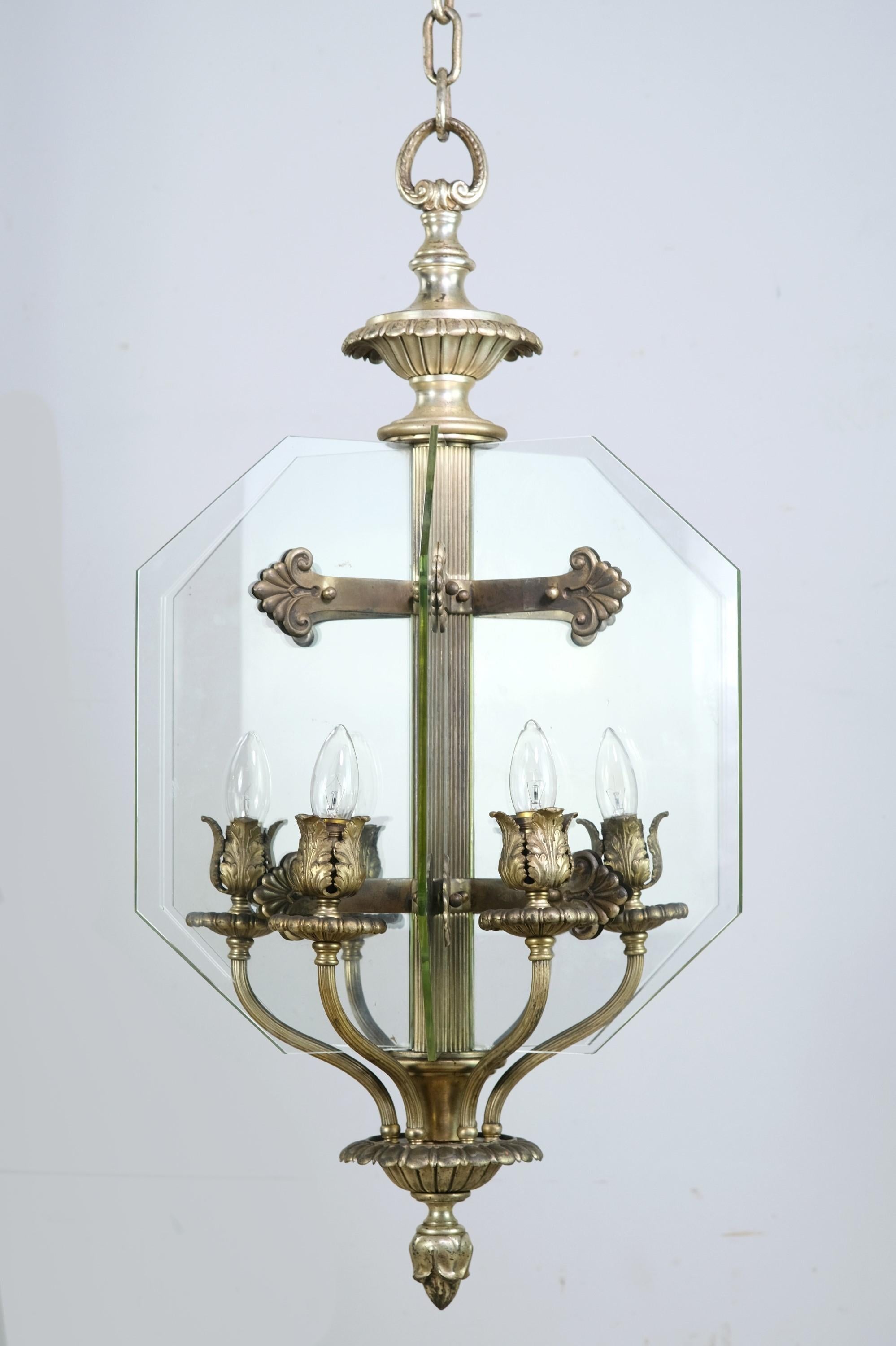 Early 20th Century pendant light by EF Caldwell that was retrieved from a Texas bank. Sliver plated bronze construction featuring 6 new beveled glass panes arranged in a hexagonal pattern. Still has the original chain and canopy. Small quantity