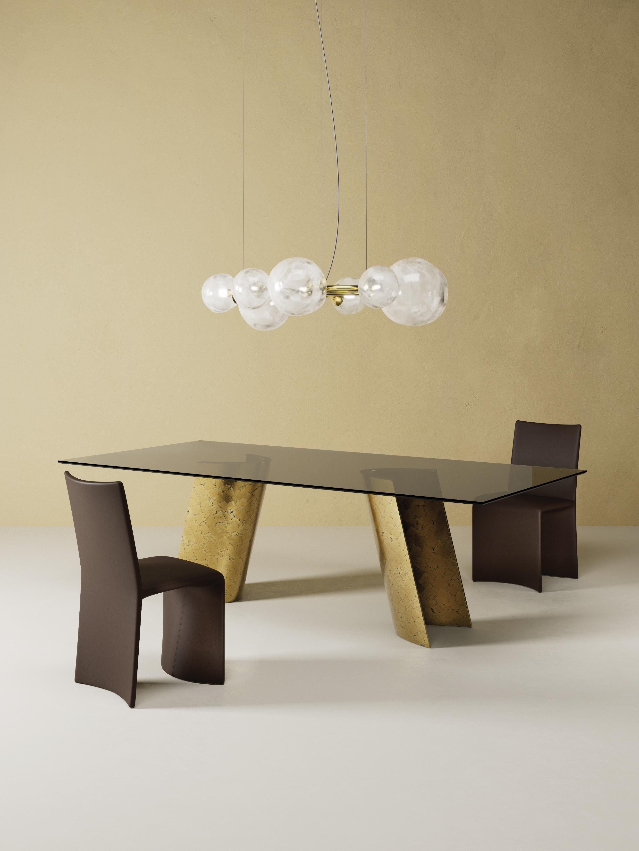 Efesto Dining Table by Chinellato Design
Dimensions: W 250 x D 120 x H 72 cm
Materials:
Top: Smooth Bronze Tempered Glass top.
Base: Gold 1 Large Pieces with Black Background finish.

Who better than the industrious god, a skilled craftsman, knows