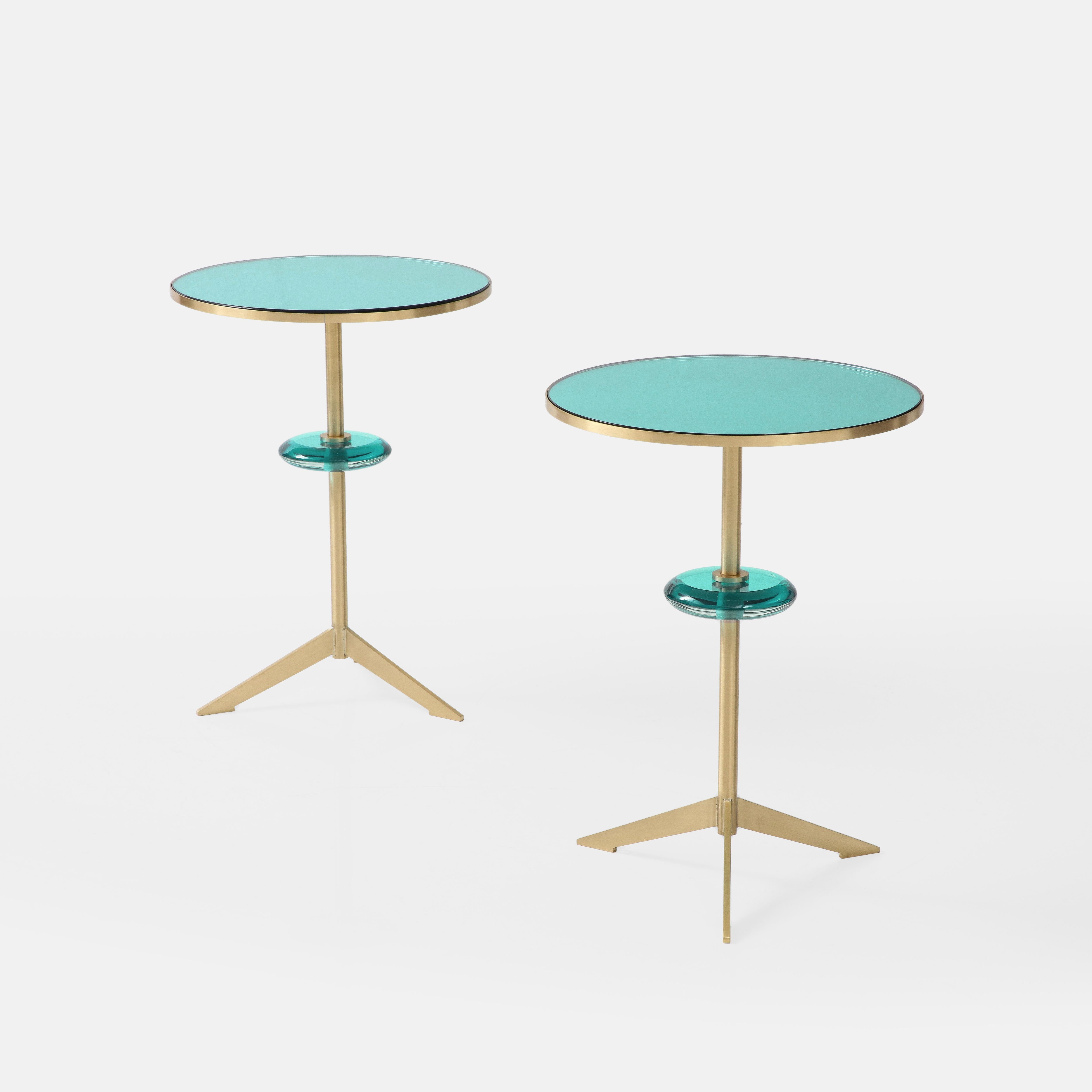 Effetto Vetro exquisite custom contemporary pair of round side tables with green glass mirrored tops inset on satin brass tripod bases with floating green glass orbs suspended on brass stems. This exquisite pair of modernist sculptural side tables