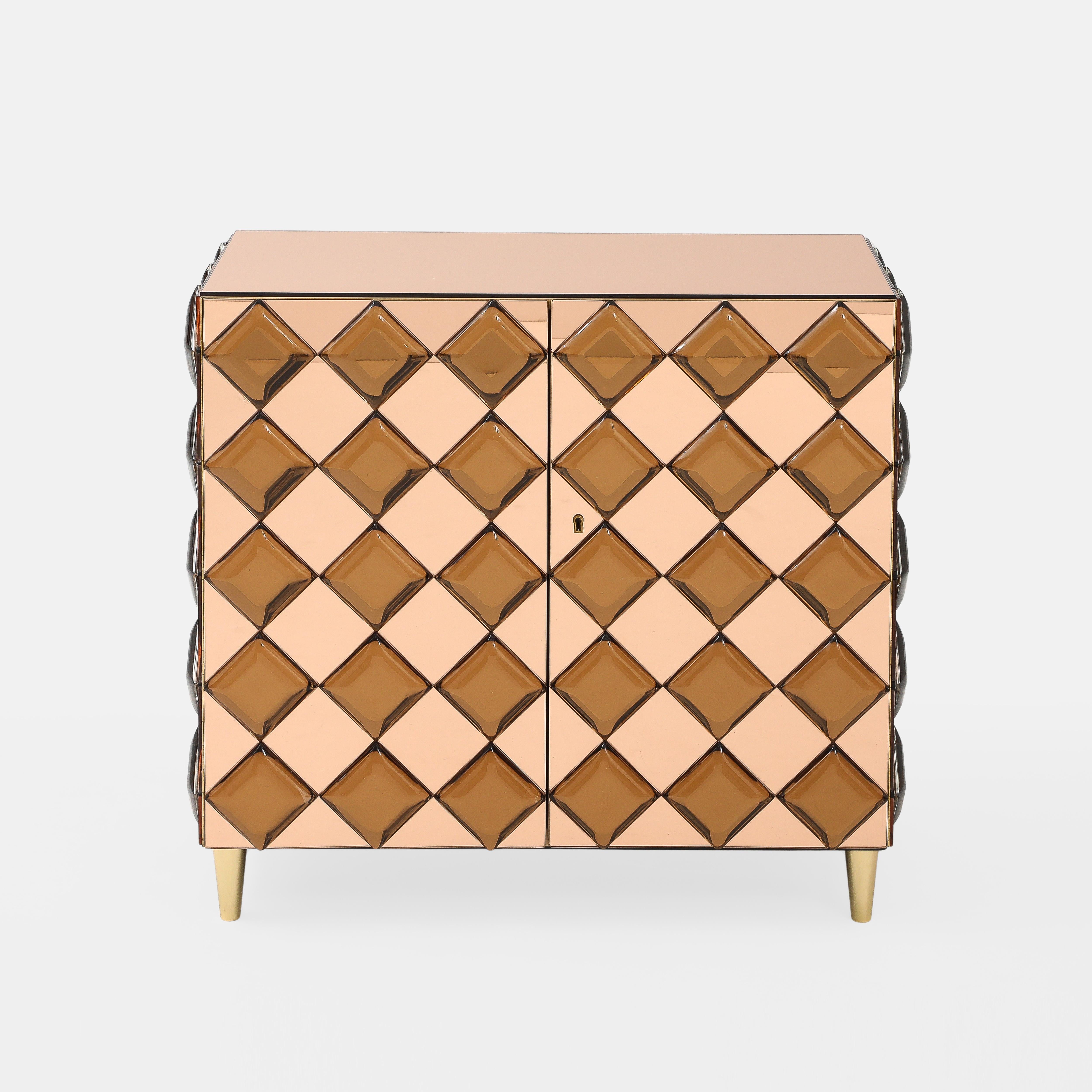 Effetto Vetro exquisite custom two-door cabinet with thick cut and diamond shaped amber colored glass against a rose crystal mirrored glass background and cabinet top ending on tapering gilt brass legs.  This extraordinary cabinet is expertly