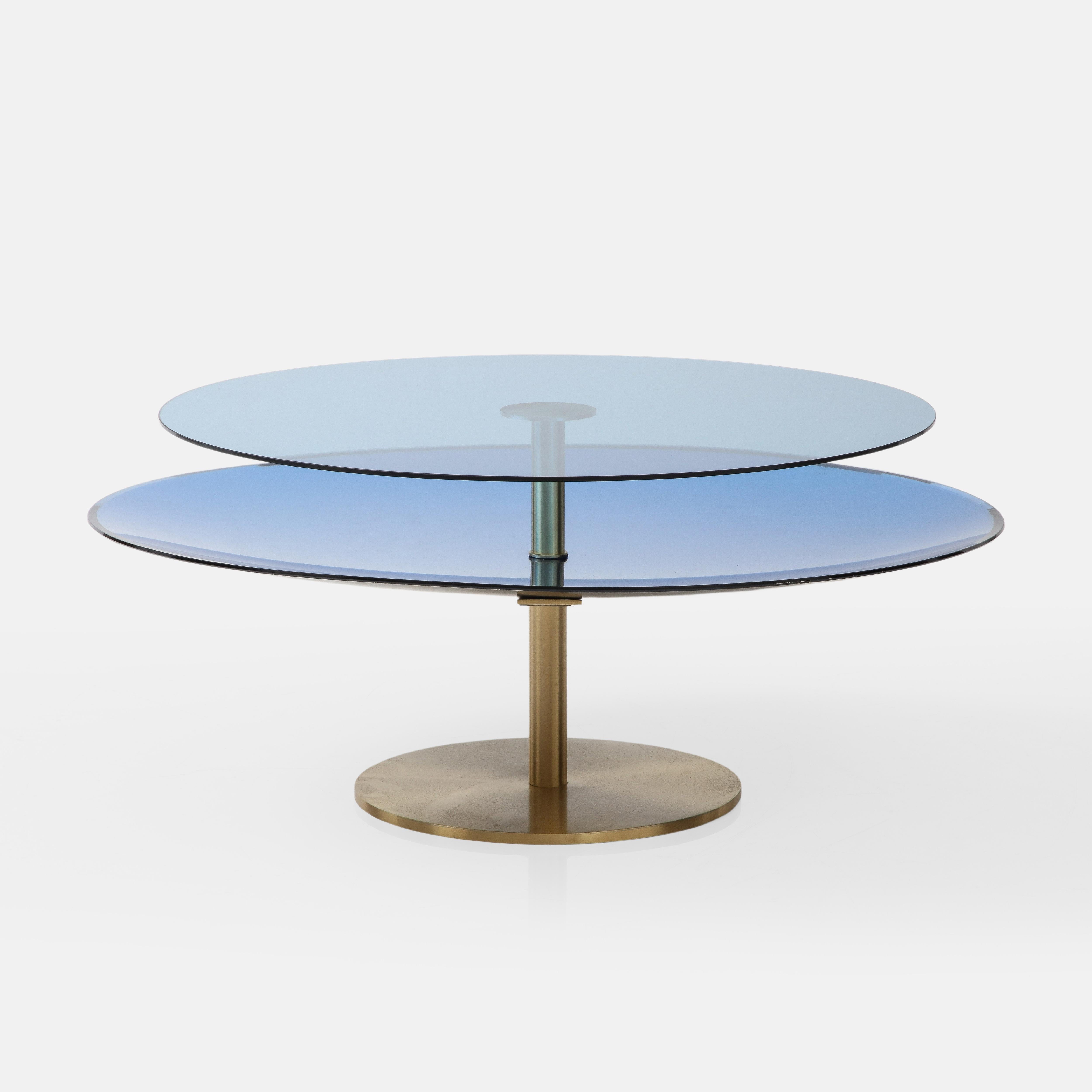 Effetto Vetro exquisite custom contemporary two tier round coffee table consisting of a colored concave mirrored glass disc below with a clear colored flat glass disc above mounted on a brushed brass pedestal structure. This lovely sculptural coffee