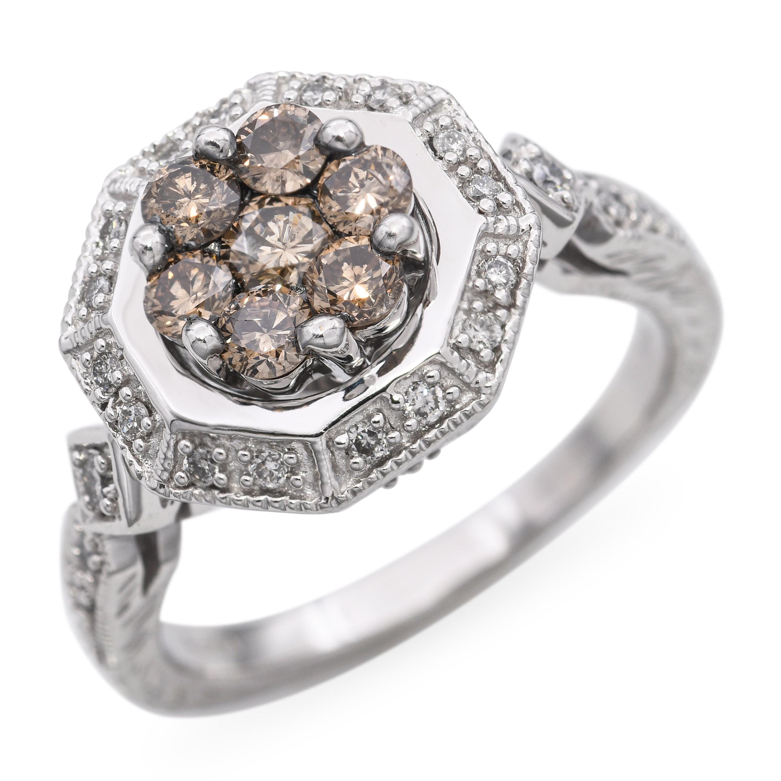 This unique vintage ring is crafted in 14k white gold and showcases a warm brown diamond center cluster, surrounded by bright white diamond accents for striking contrast. The total carat weight of 0.95ctw offers plenty of sparkle while maintaining a