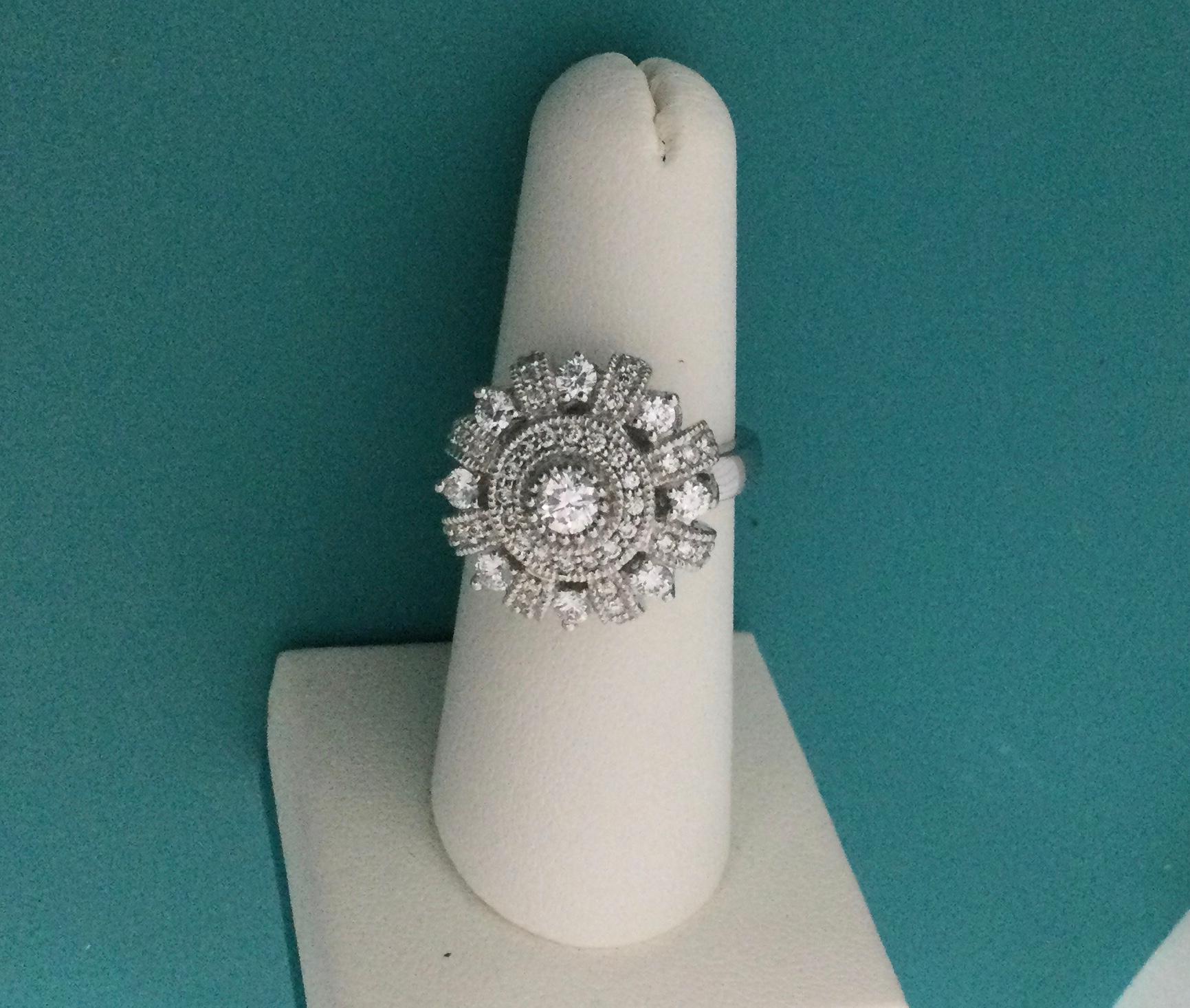 An exquisite EFFY ring designed in the shape of a large round flower  or crown will look beautiful resting on a person's finger. Crafted from 18k white gold, the flower has a central diamond surrounded by smaller diamonds in different patterns,