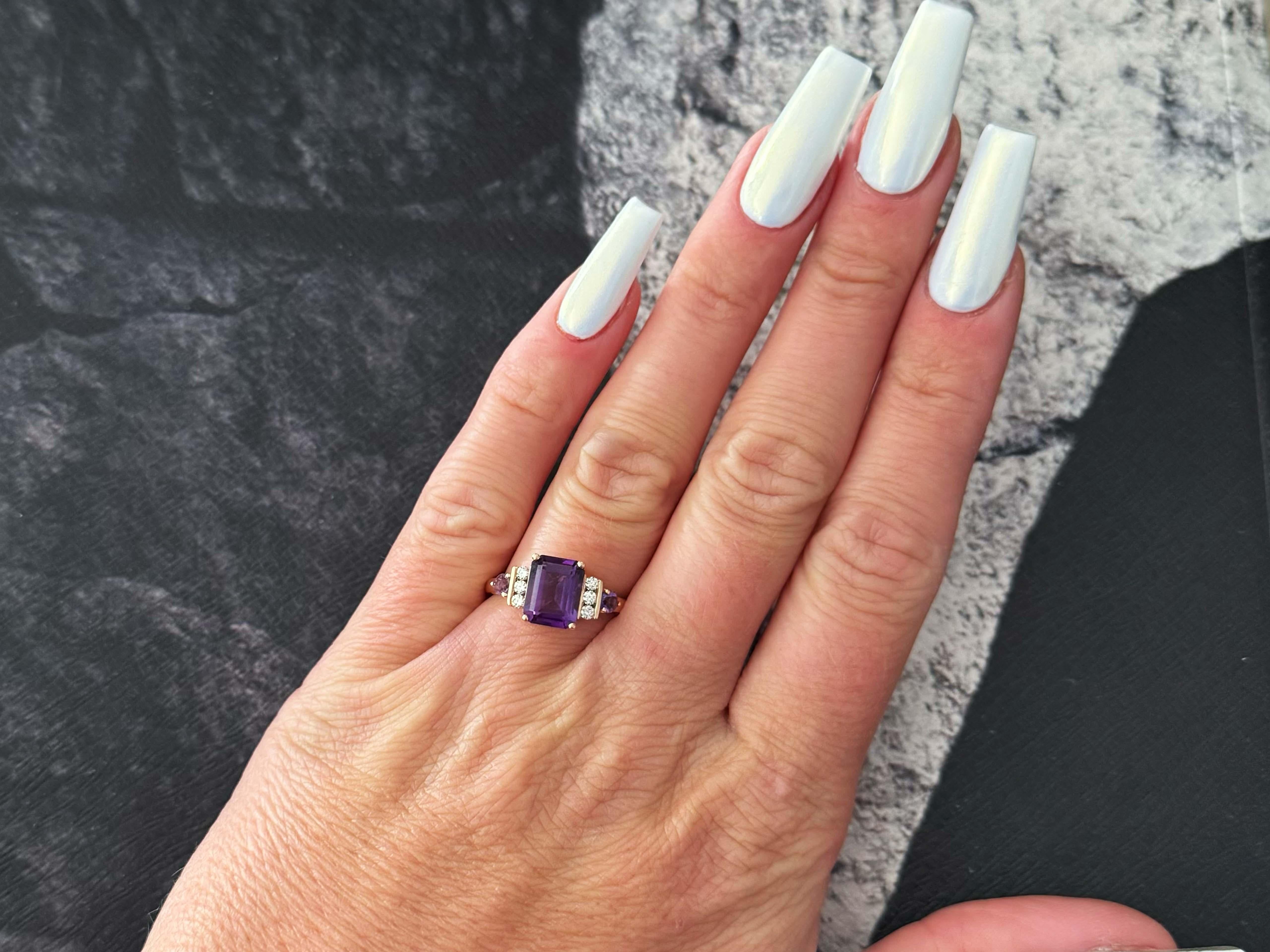 Ring Specifications:
​
​Designer: EFFY

Metal: 14k Rose Gold

Total Weight: 3.4 Grams

Diamond Count: 6

Diamond Clarity: SI

Diamond Color: G

Diamond Carat Weight: 0.12 carats

Gemstone: 1 emerald cut amethyst and 2 round amethyst
​
​Emerald Cut