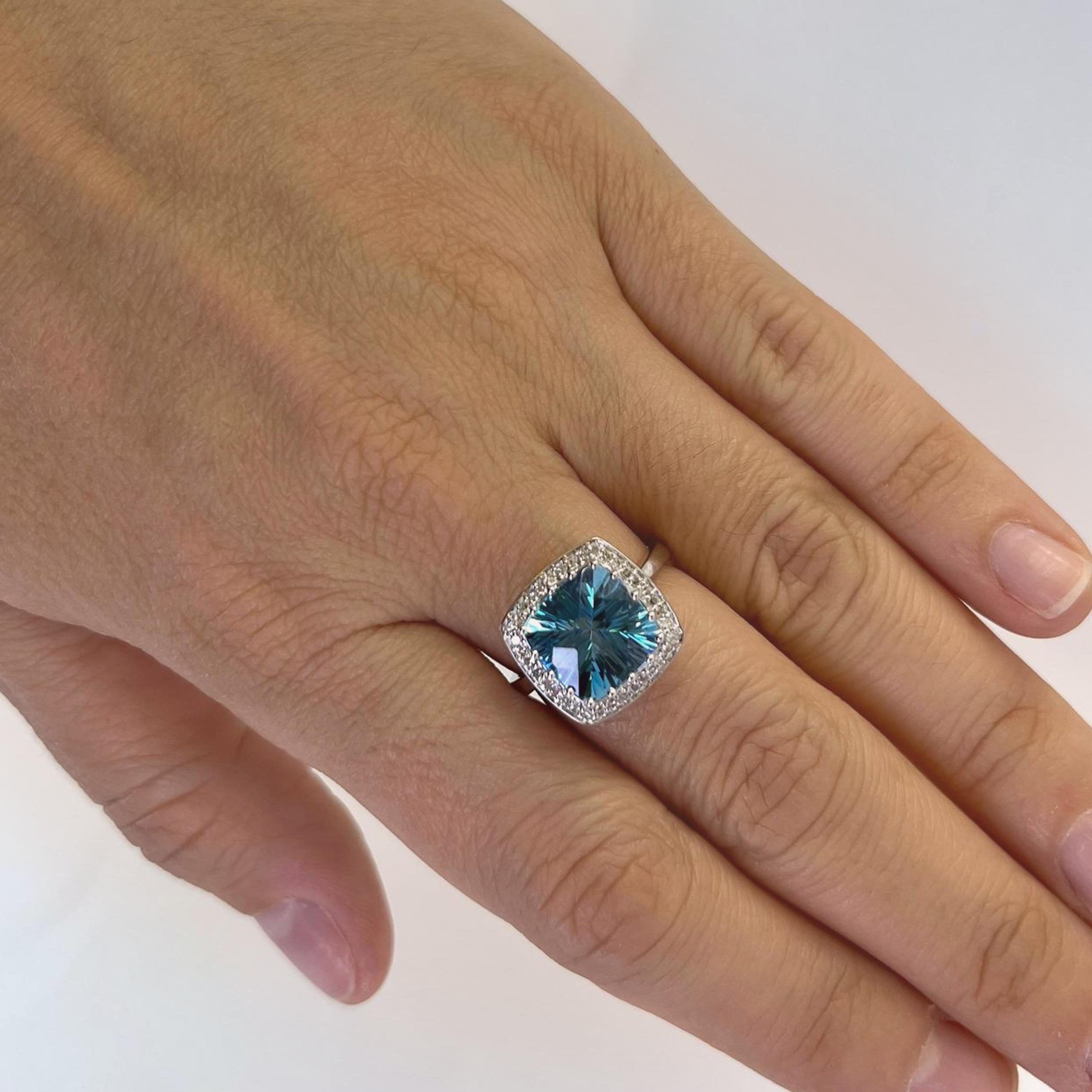 Anillo de cóctel Effy de oro blanco de 14 quilates con un topacio azul talla cojín de fantasía de 10 mm rodeado de 36  Diamantes redondos de talla única de claridad VS y color G/H que suman aproximadamente 0,18 quilates. Dedo talla 7. Incluye un