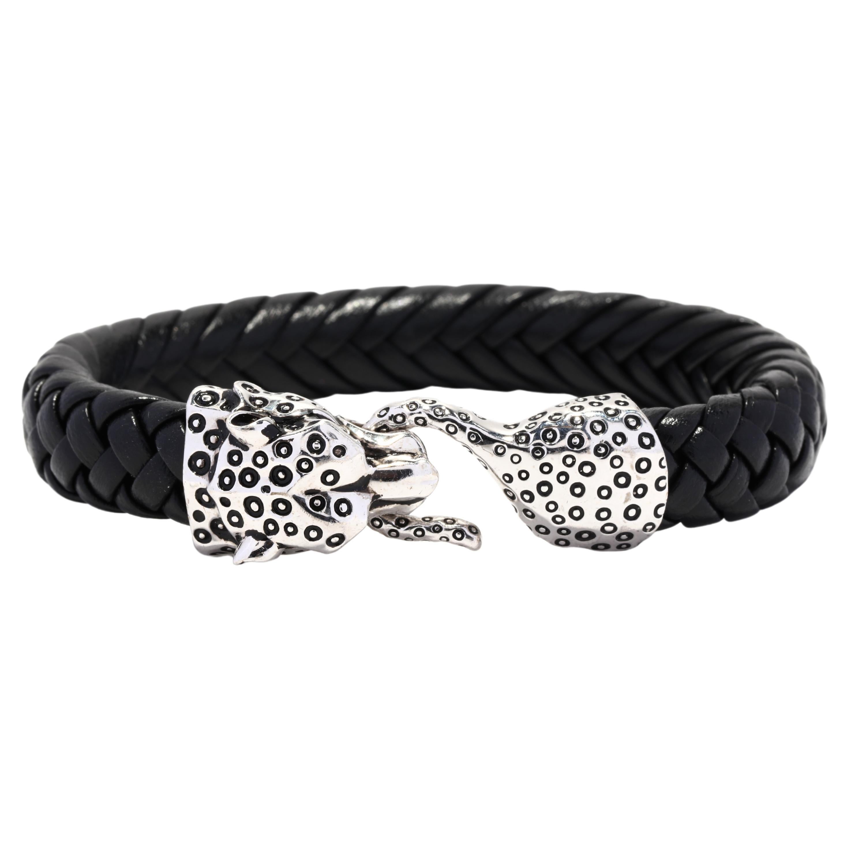 An Effy sterling silver cheetah braided leather bracelet. This gent's leather bracelet features a black braided leather bracelet with a cheetah head motif hook and eye clasp.

Length: 7.75 in.

Width: 5/8 in.

Weight: 21.6 dwts. / 33.6