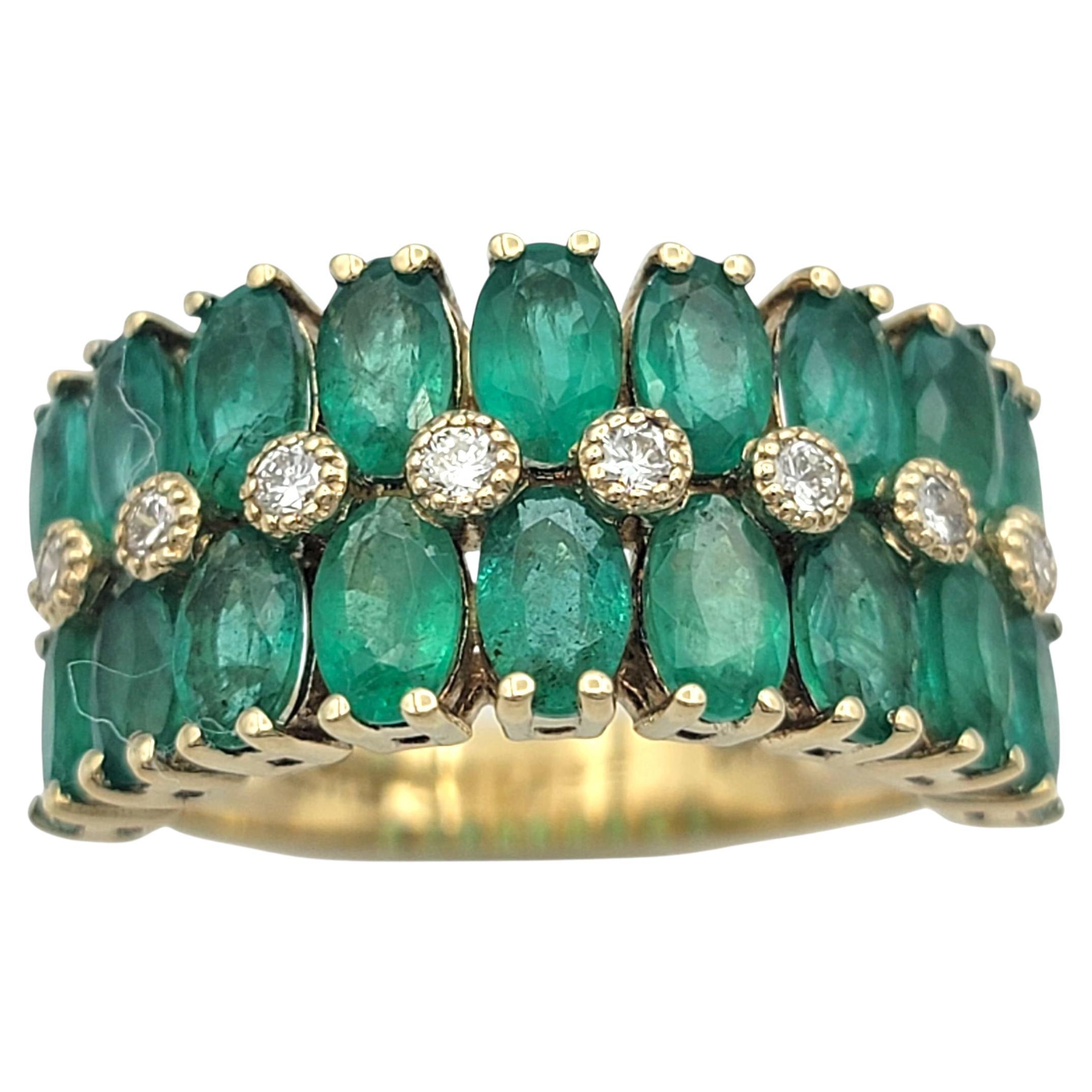 Cette vibrante bague Effy est réalisée en or jaune 14 carats et présente deux rangées d'émeraudes vertes de taille ovale encadrées par une ligne de diamants de taille ronde. Les émeraudes sont serties les unes contre les autres, formant une bande