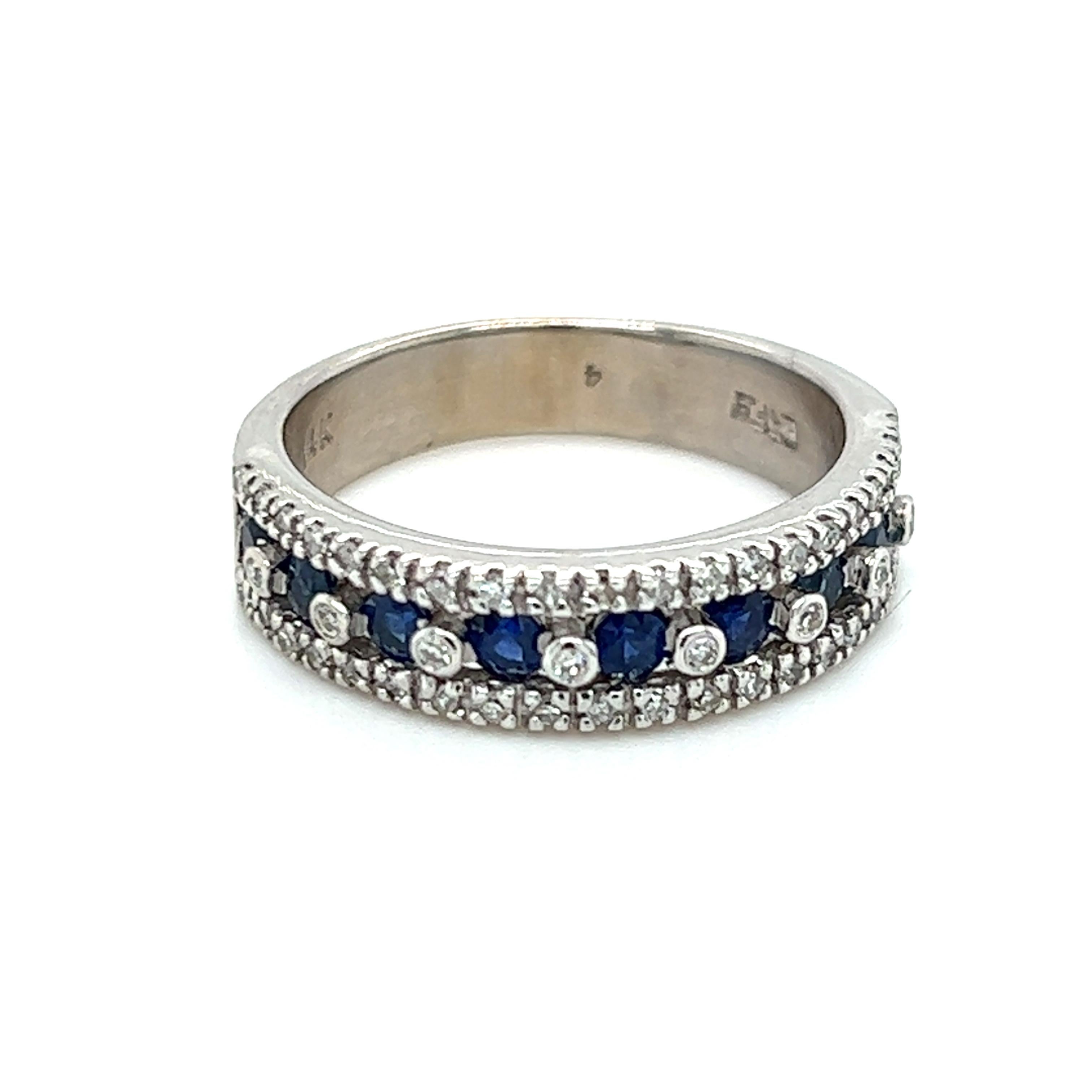 One 14-karat white gold band set with nine (9) 2.75mm round natural blue sapphires and fifty-five (55)  brilliant cut diamonds, approximately 0.50-carat total weight with matching I/J color and SI/I1 clarity.  The top of the ring measures 5.52mm and