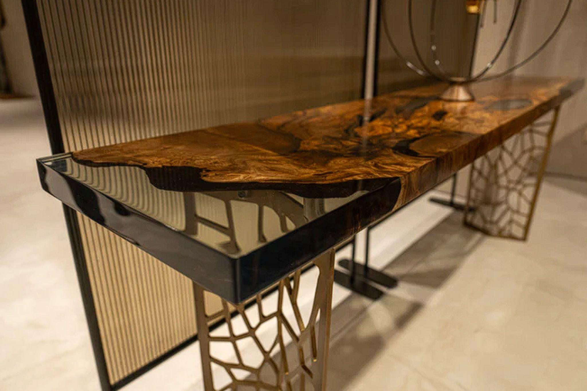 Crafted from premium-quality walnut wood, the EFIL console boasts a unique design that beautifully blends the natural wood with crystal-clear resin epoxy. 

The console also features sleek aluminum metal legs that add a touch of modernity to the