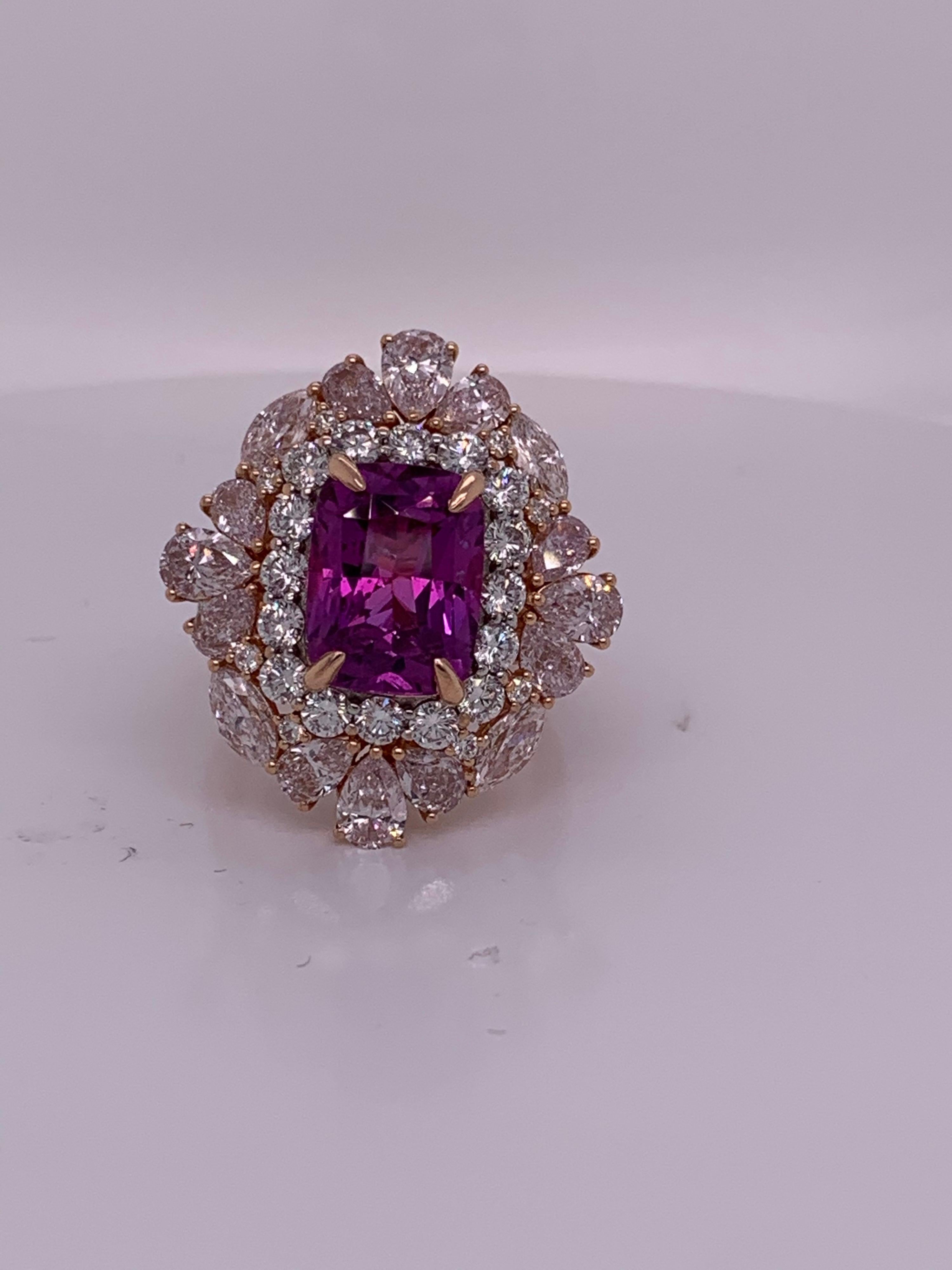Der natürliche, nicht erhitzte lila Saphir ist ein begehrter Edelstein. Dieser prächtige, kissenförmige Saphirring hat einen weißen Diamantenhalo, der von glitzernden rosafarbenen Diamanten umrahmt wird, und ist von Hand in Zacken gesetzt.
Violetter