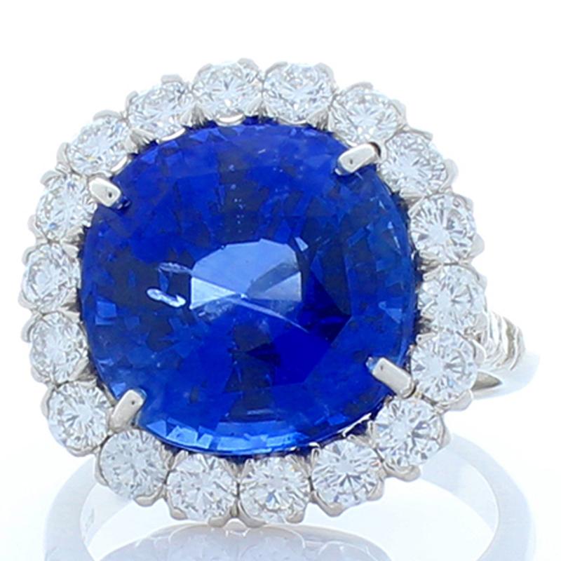 This is a lavish cocktail ring created in brightly polished platinum and features a 12.63 carat oval sapphire. Its color is vibrant royal blue; measures 12.57x12.52x9.36mm. The gem source is Sri Lanka; its transparency and luster is excellent. The