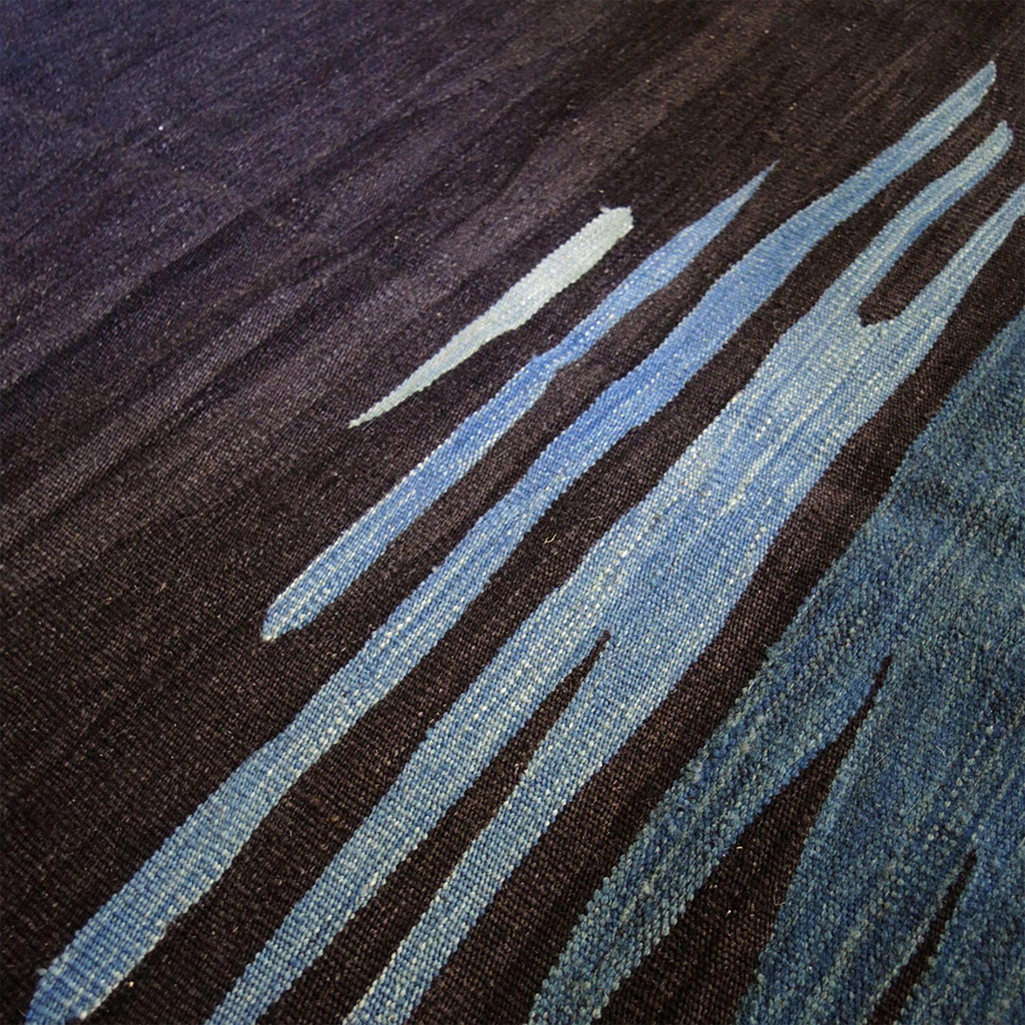 Le tapis kilim Ege No 1 fait partie d'une série de kilims qui reflètent une admiration pour l'expressivité visuelle et émotionnelle de la surface de la mer, avec ses mouvements fluides et ses reflets de couleurs qui créent un effet relaxant sur la