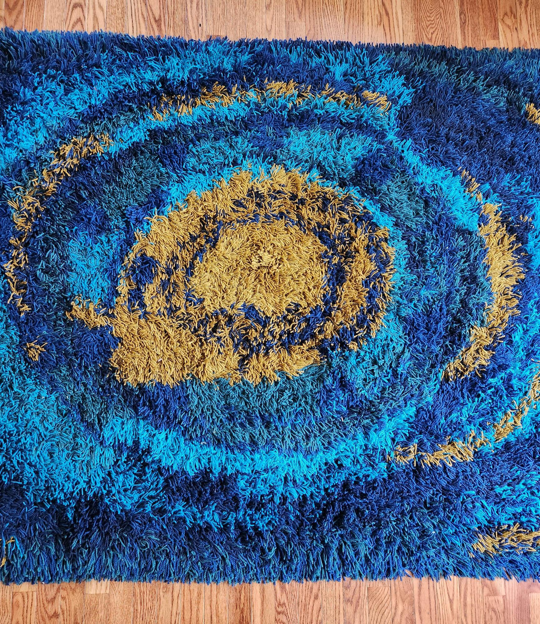 Ege Tæpper Sun Burst Tapis,
Ege Rya,
Fin des années 1960-début des années 1970

Le tapis en laine Ege Tæpper est un merveilleux exemple de ce design emblématique des tapis Modern Scandinavian.  Le tapis a un fond bleu intense avec un soleil central