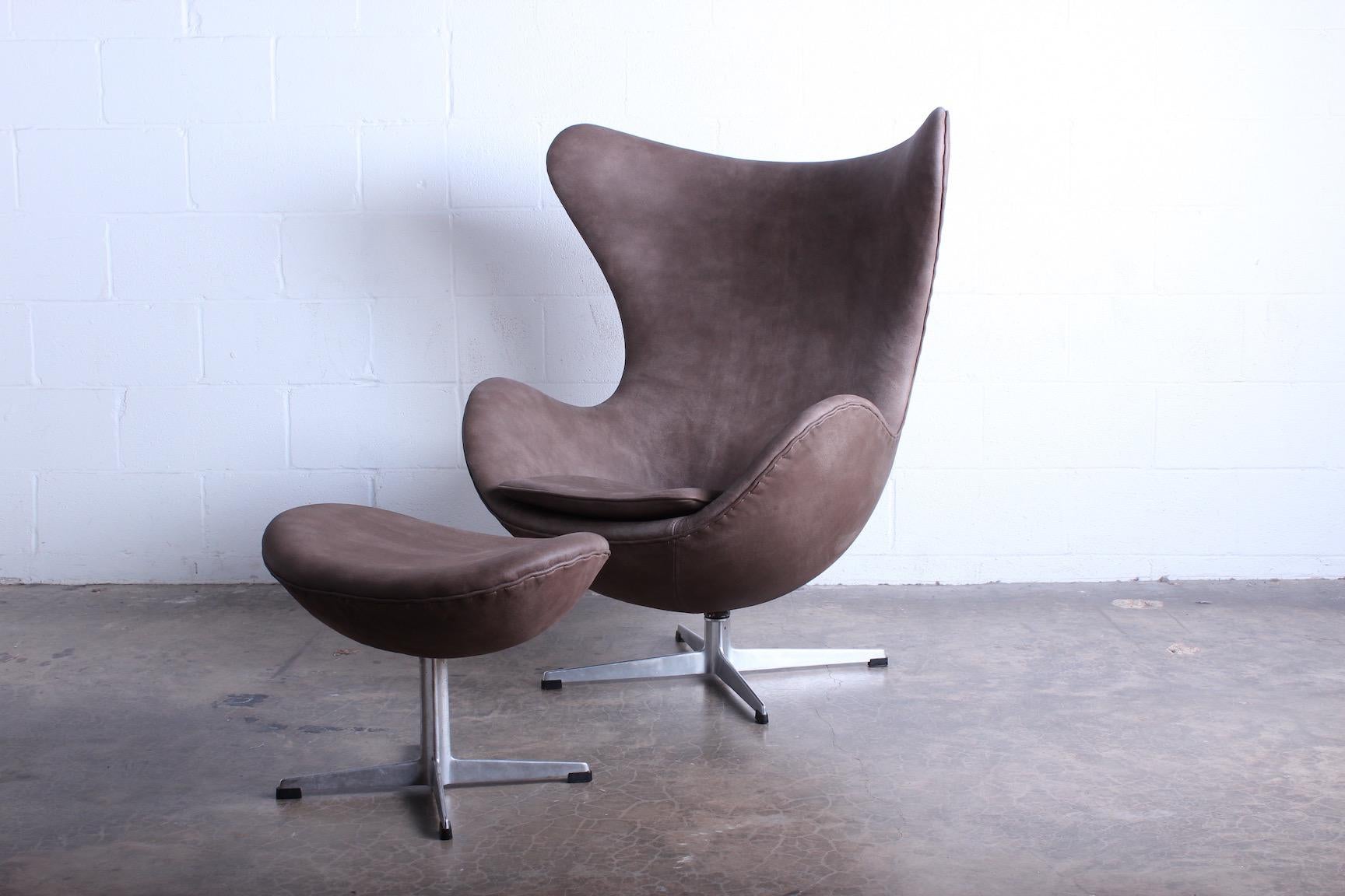 A leather egg chair and ottoman designed by Arne Jacobsen for Fritz Hansen.