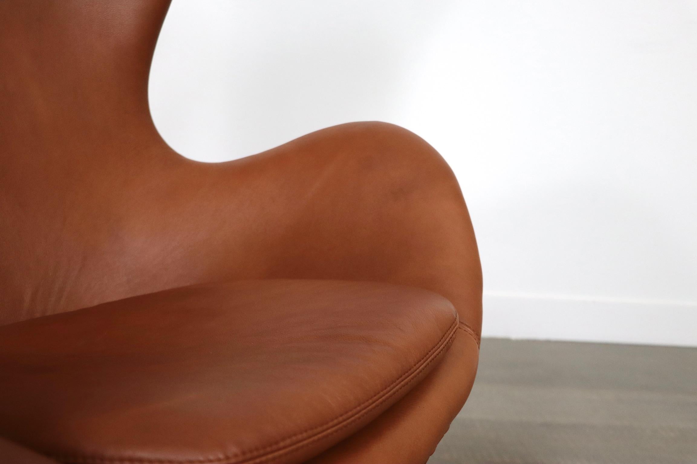 Beautiful early model egg chair with ottoman in brown leather by Arne Jacobsen for Fritz Hansen, 1960s. The number on the original label (0763) shows the chair and ottoman are produced in 1963. This incredibly comfortable chair has become an icon