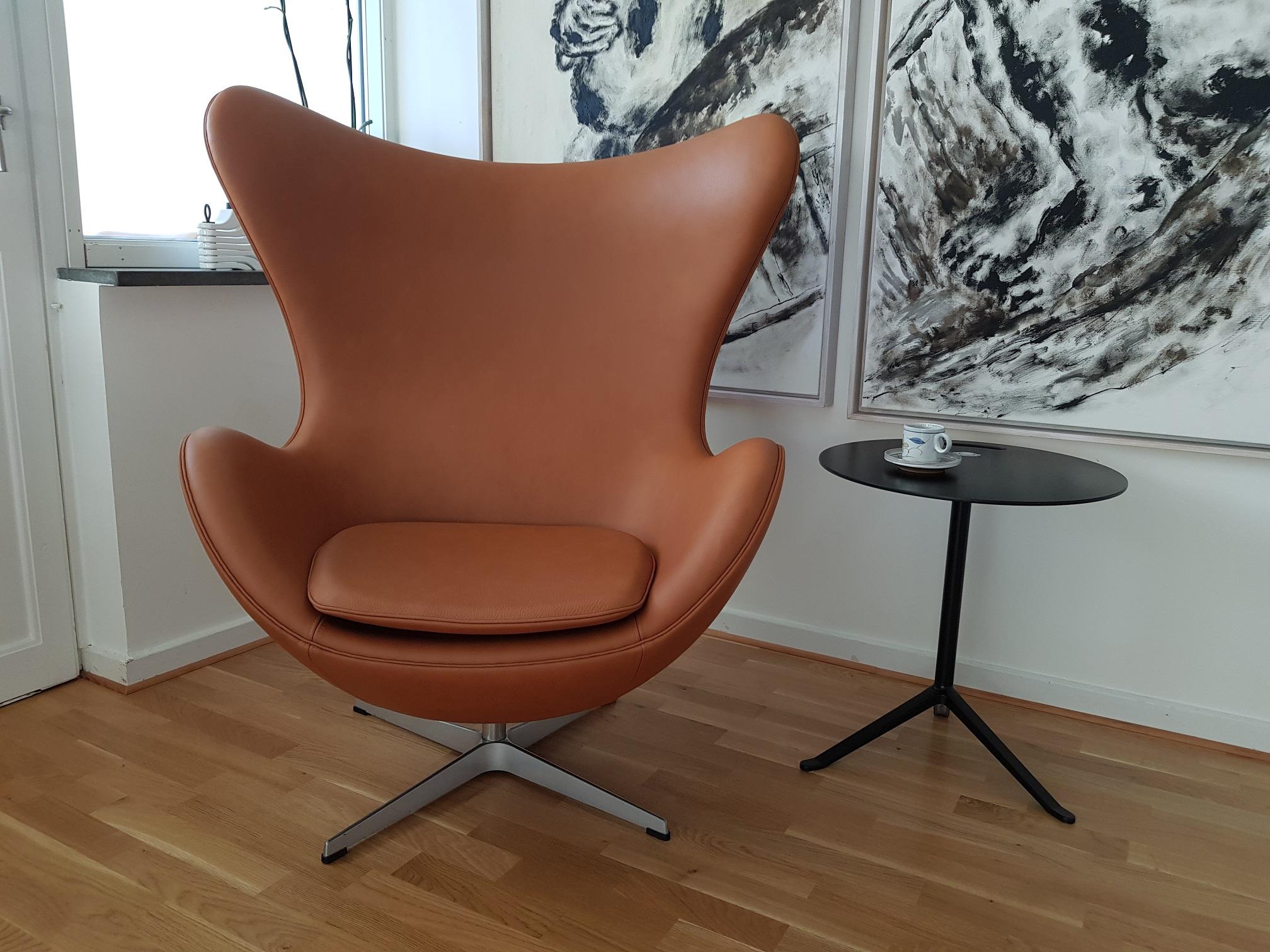 The Egg chair, newly upholstered in calvados classic leather. The tilt mechanism makes the chair adjustable and more comfortable. Produced in 2003 and upholstered in Denmark in 2018 with semi-aniline leather. This iconic chair is one of the most
