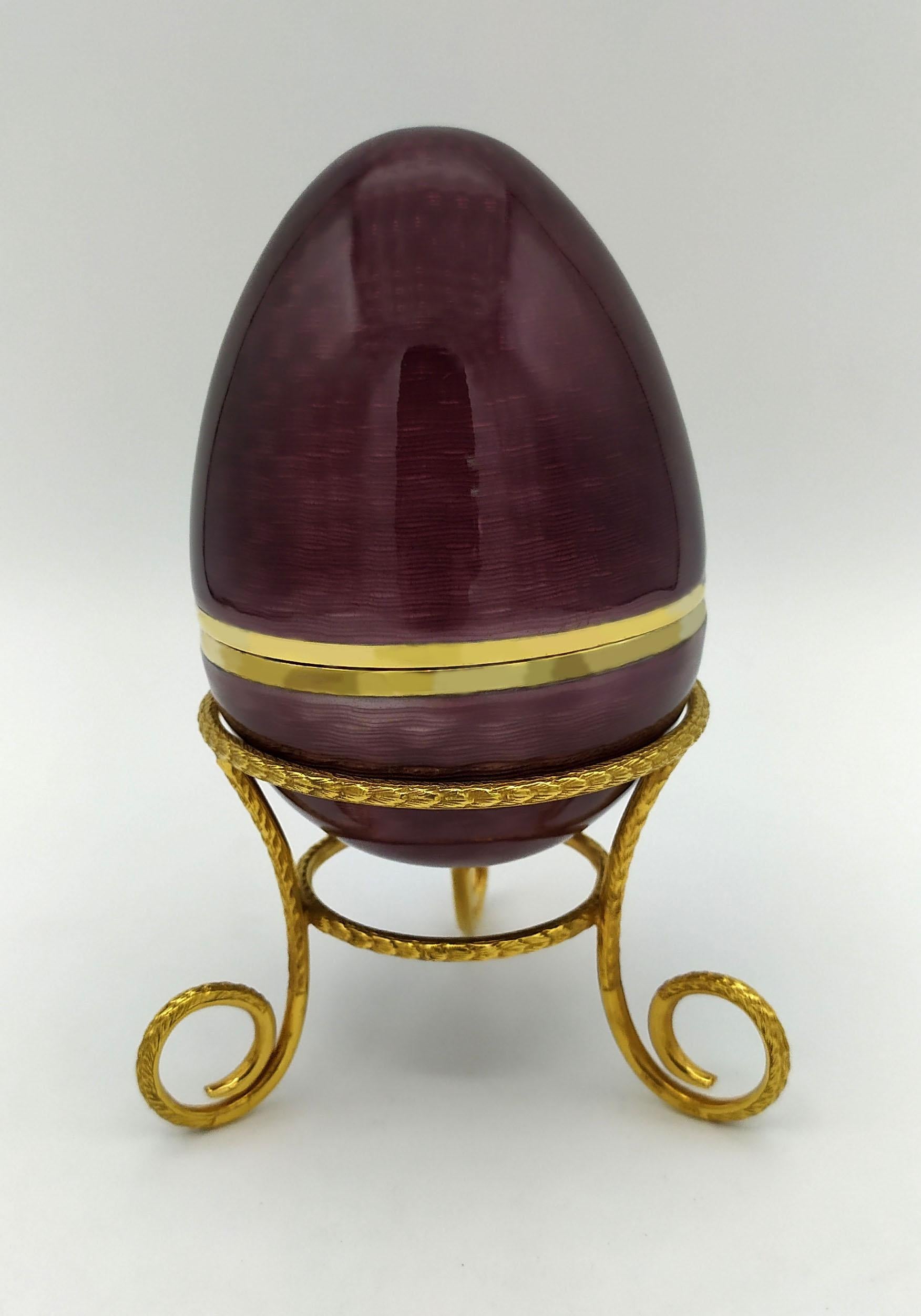 Ei auf Dreibein in 925/1000 Sterlingsilber vergoldet mit durchscheinendem gebranntem Email auf Guillochè, im Stil des russischen Empire, inspiriert von Carl Fabergè Eiern Ende 1800, Anfang 1900. Maße: Durchmesser des Eies cm. 6,7 cm hoch. 9,7 ruht
