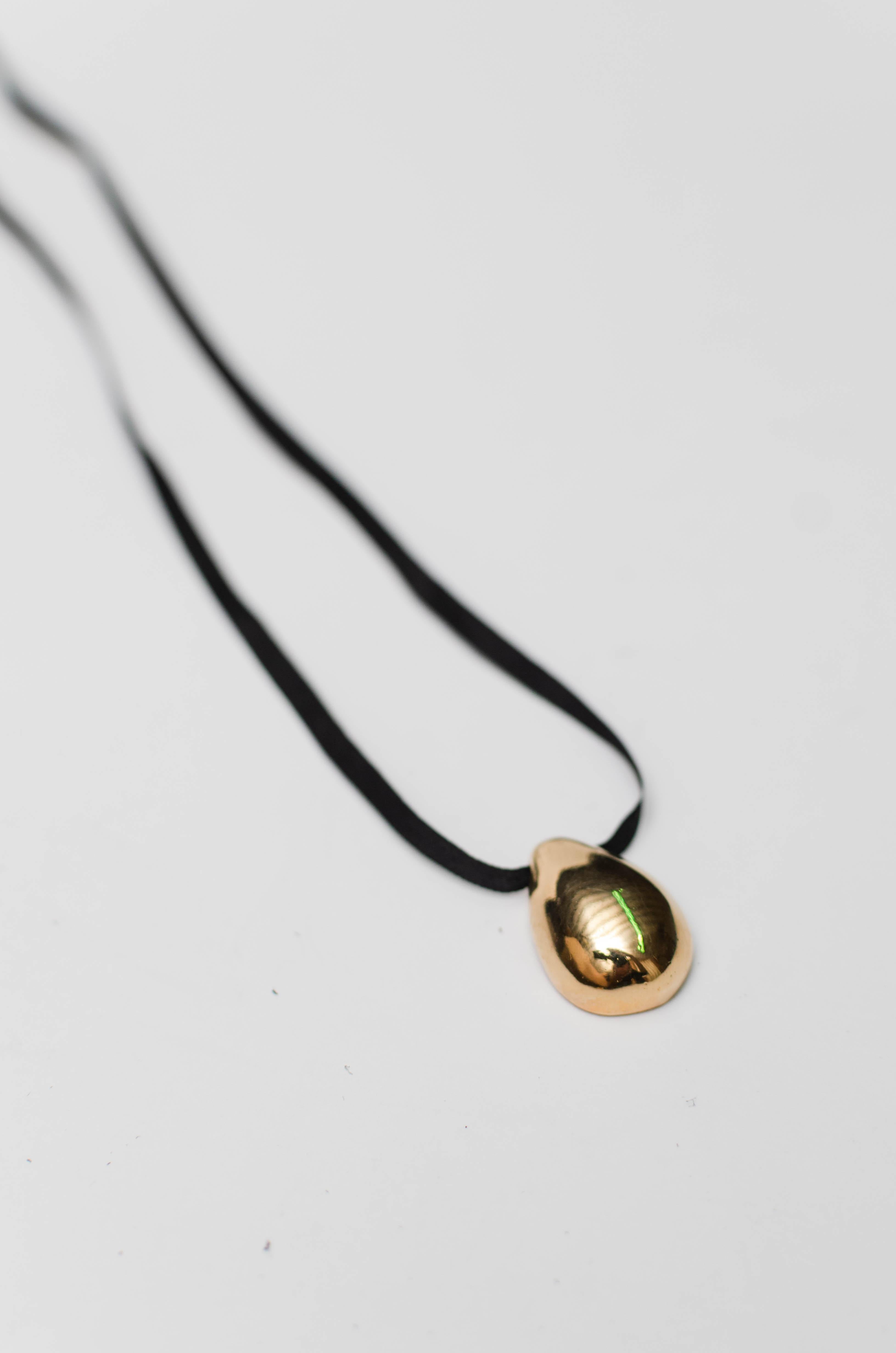 These pieces were designed, hand-carved, and then cast from our workshop in Uruguay.
Beautiful necklace with a delicate gold-plated silver pendant threaded on a black silk lace with gold-plated silver terminals.
All these processes make a truly