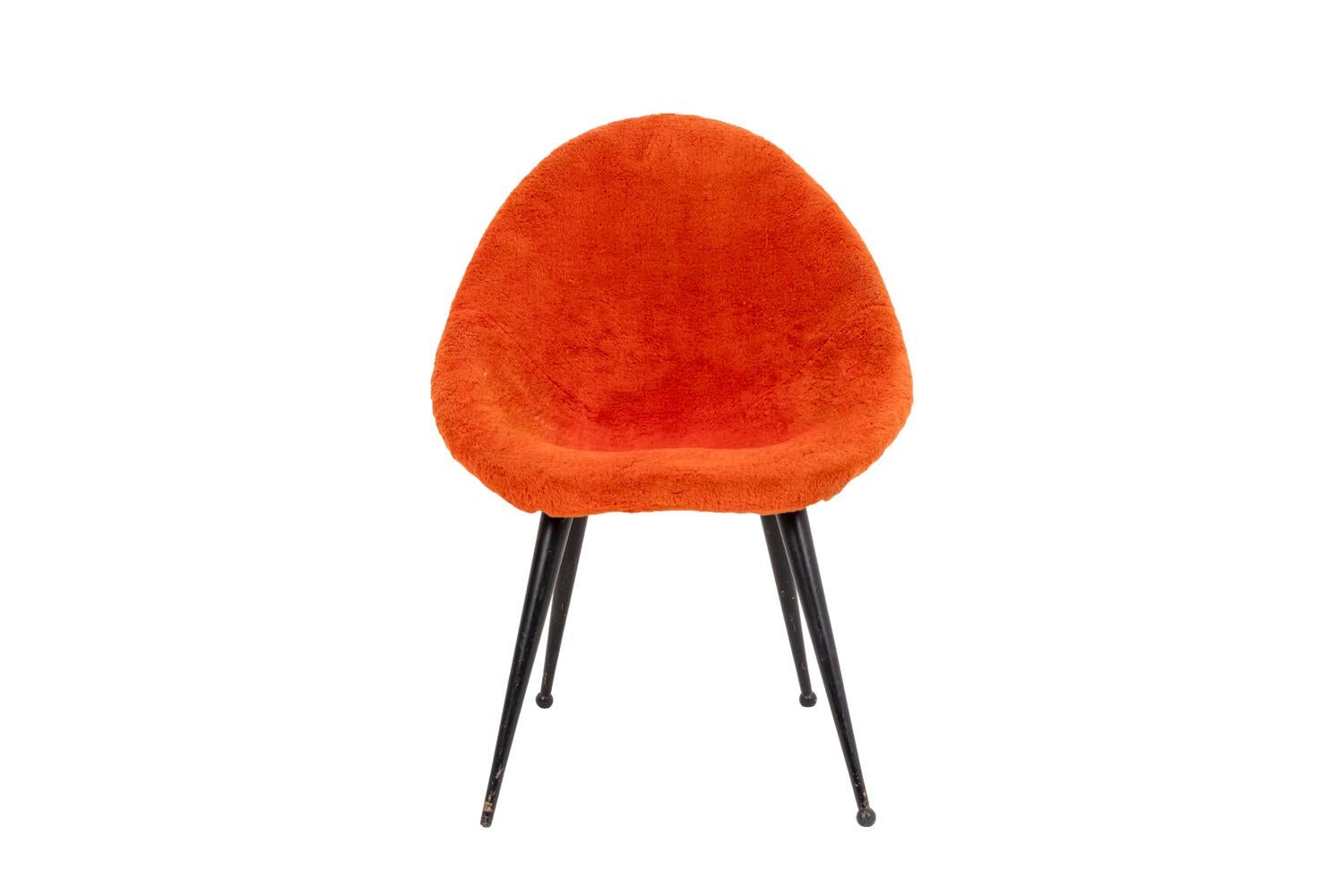 Egg-shaped armchair standing on four tapered legs in black lacquered metal ending by balls. Rounded seat and back covered by red false fur fabric.

Work realized in the 1950s.