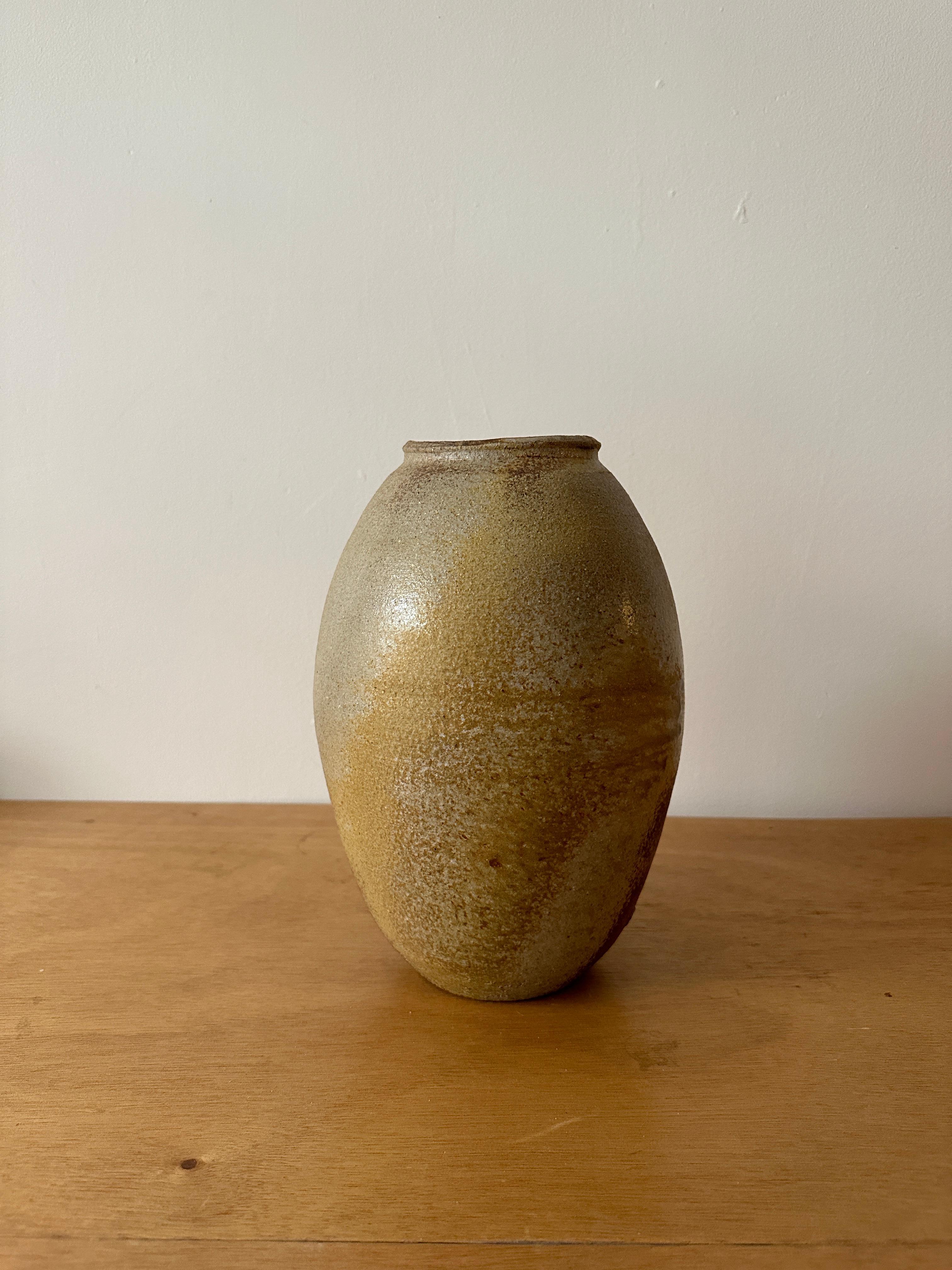A wood-fired egg shaped ceramic vase with an expressive glaze complimenting the form and the material. 