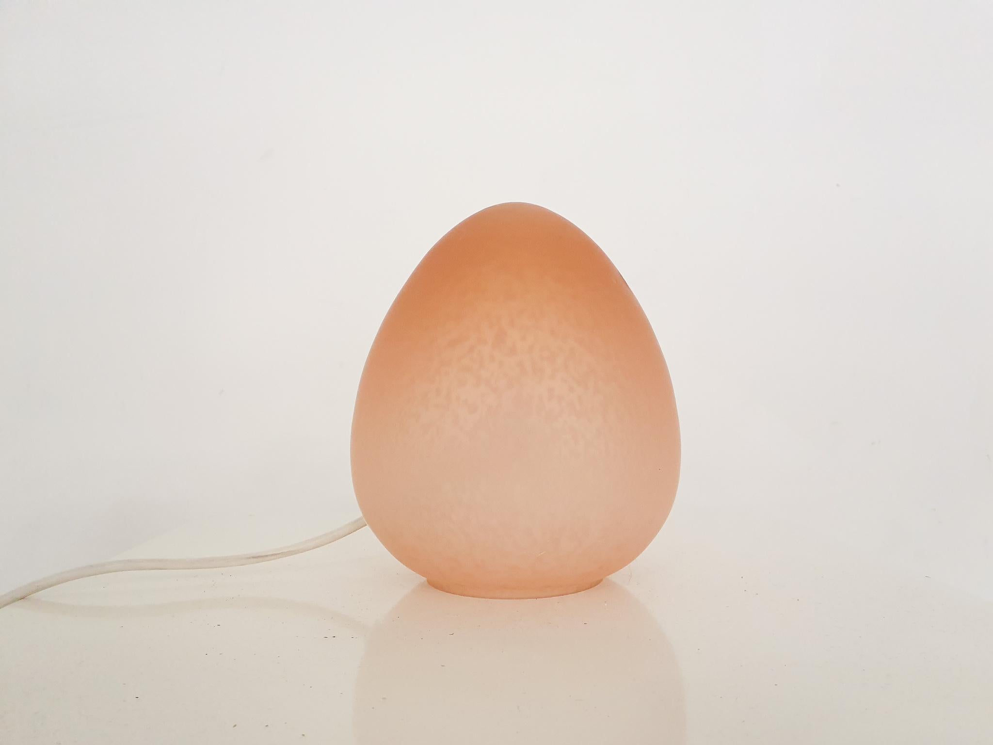 Lampe de table en verre en forme d'œuf de couleur chair.