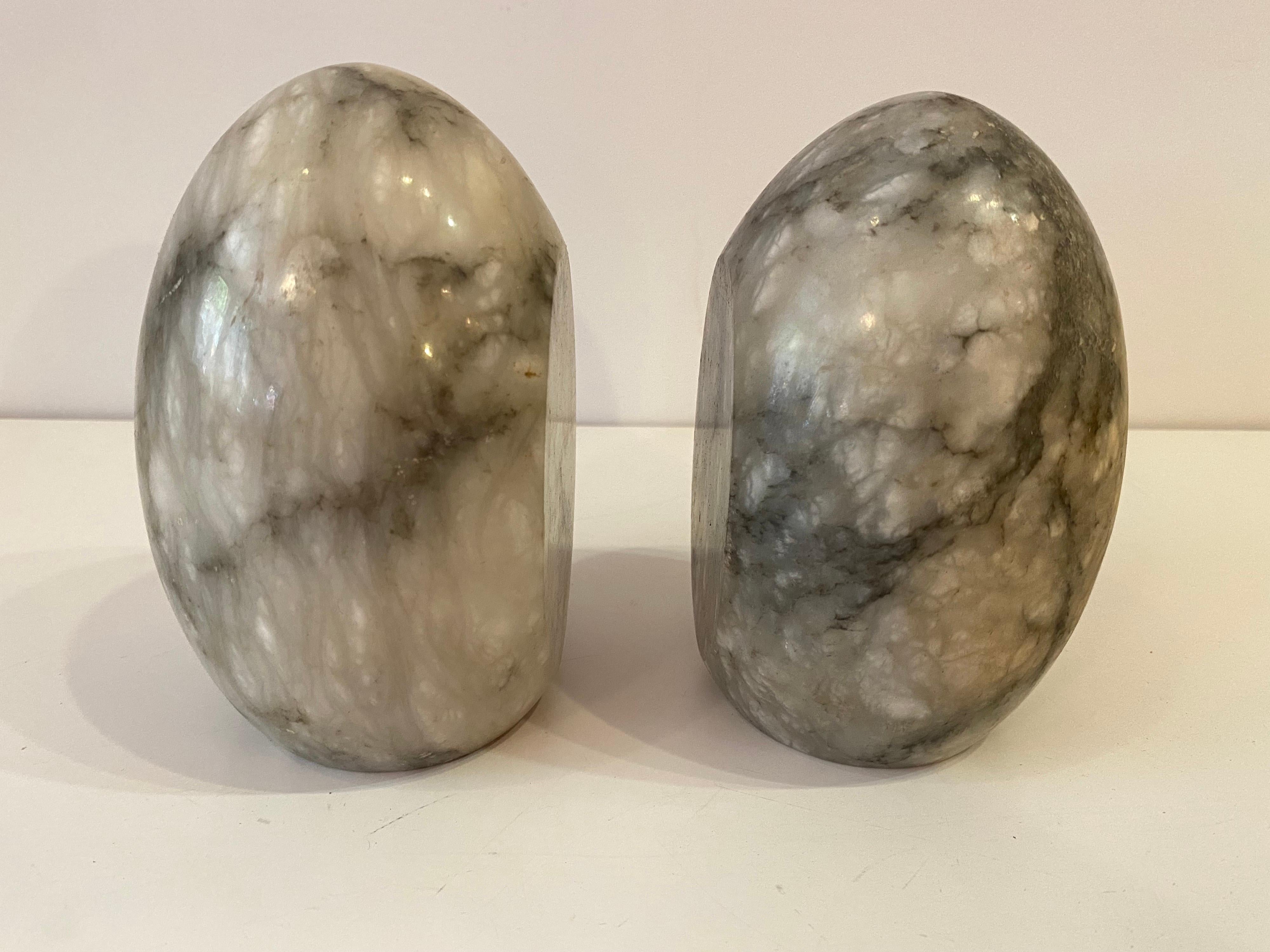 Egg shaped marble bookends. Each egg has a flat side to hold books tight! White marble with gray graining throughout. Nice size measuring 5.5 tall and 3.5 across.