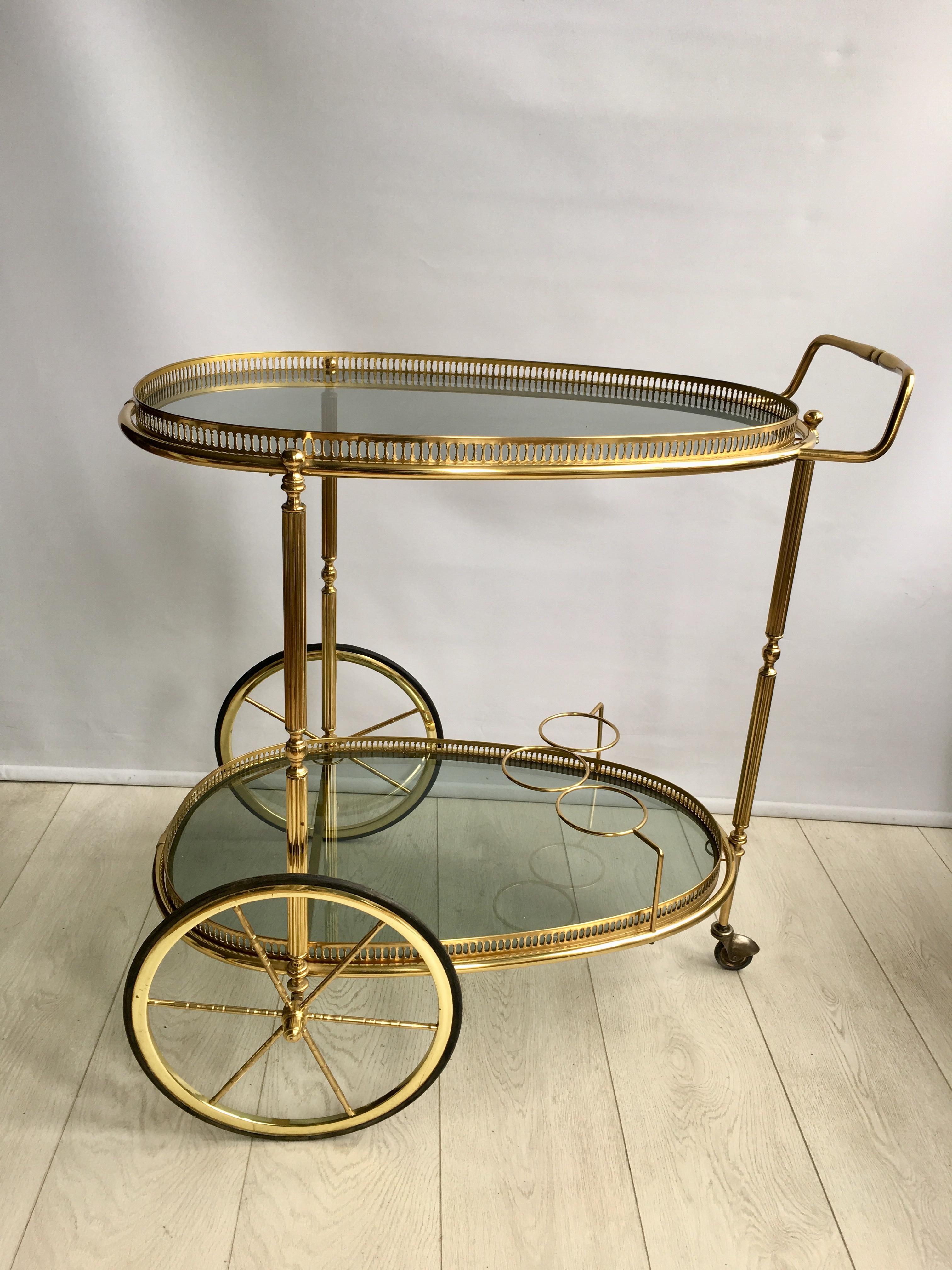 Fantastic shape to this vintage brass drinks trolley

Tinted glass shelves (could be replaced with clear glass)

Bottle holder to lower tier

France, circa 1970

Top tray measures 65.6cm wide, 43cm deep and stands 71cm tall
Overall dims