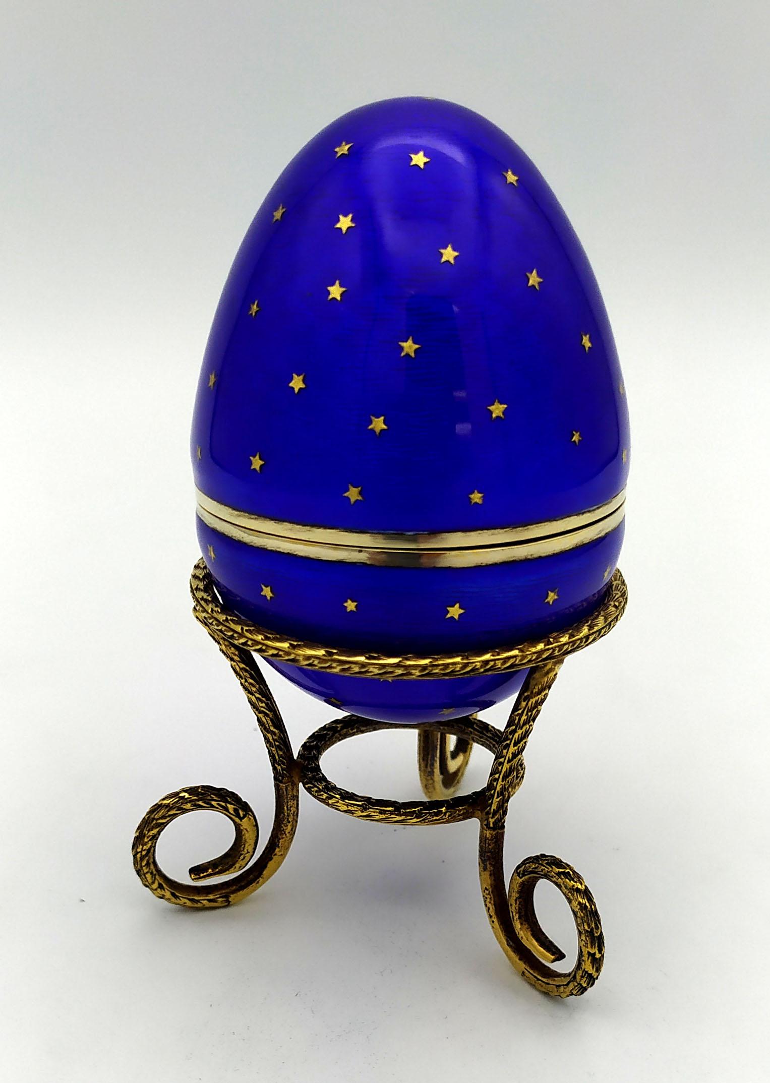 Egg with tripod in 925/1000 sterling silver gold plated with translucent blue fired enamel on guillochè and with the insertion of pure gold “paillons” in the shape of stars to create a starry sky effect. Inspired by Fabergè's Russian eggs, but with