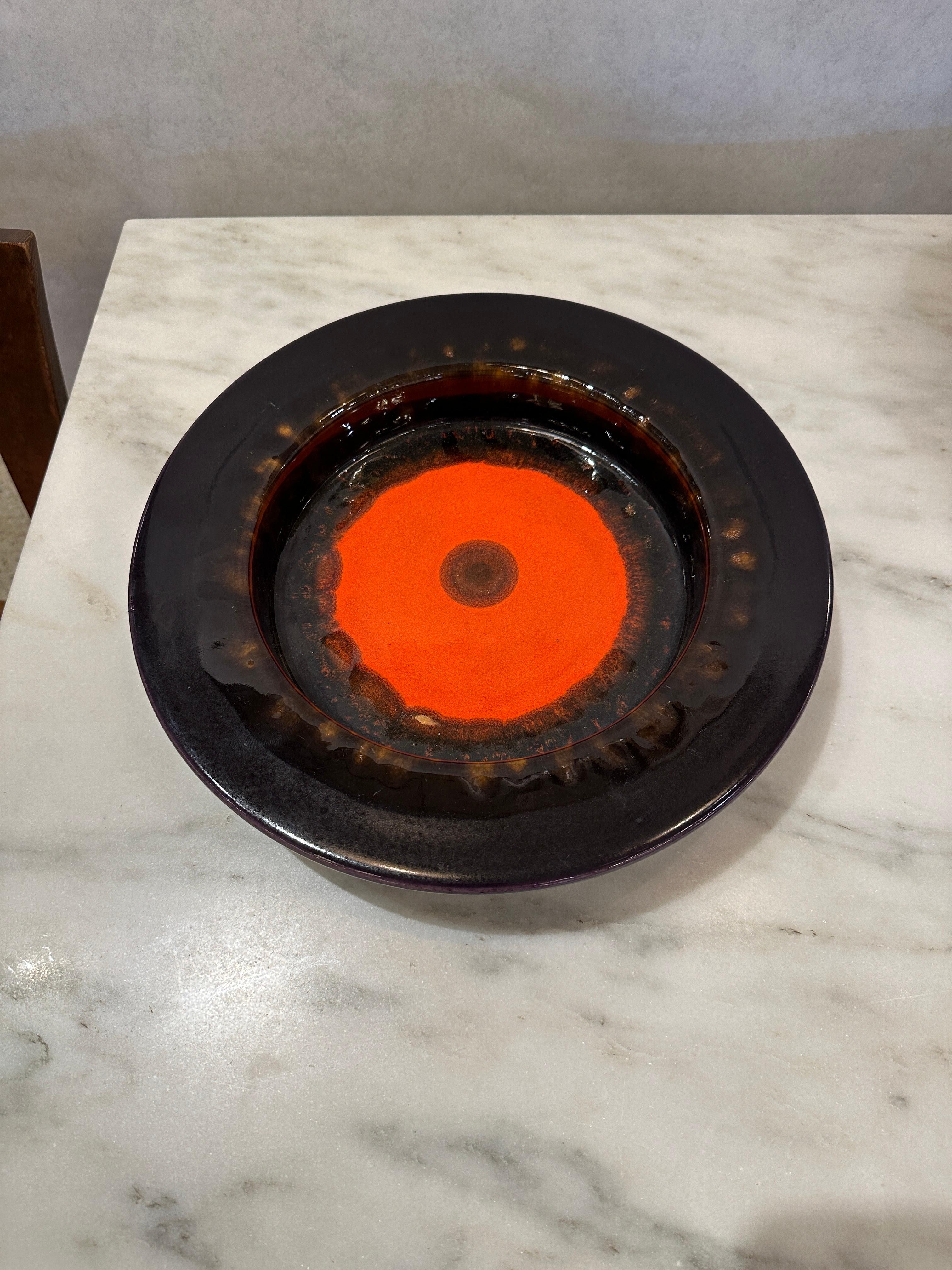 This wide lipped glazed ceramic West German bowl features vivid orange central coloring surrounded by a rich eggplant tone.  THIS ITEM IS LOCATED AND WILL SHIP FROM OUR MIAMI, FLORIDA SHOWROOM.